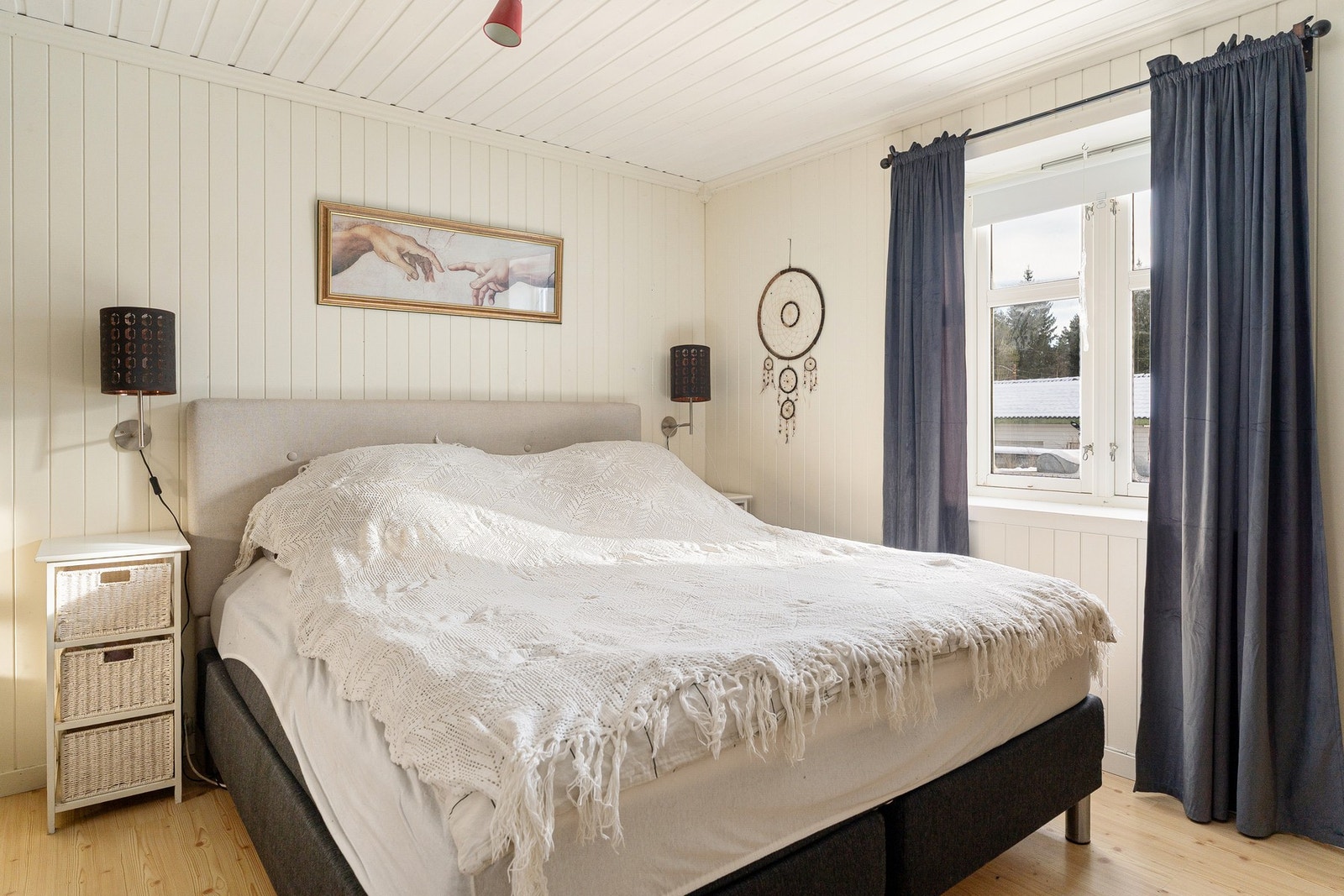 Lyst soverom med vindu som gir naturlig lysinnslipp. Vegger og tak i hvit panel. Galleribilde