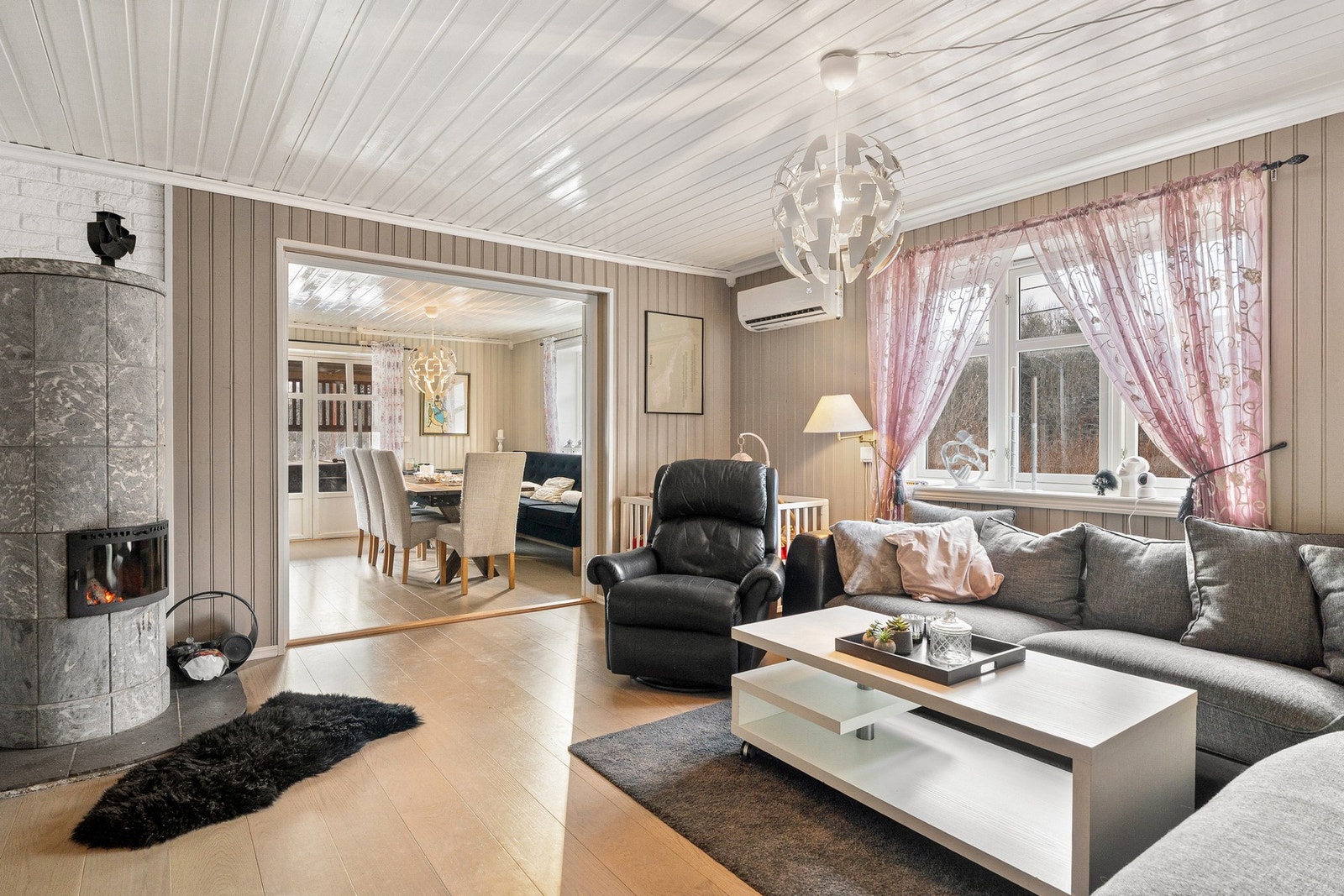 Lys stue med god romfølelse, store vinduer og åpen løsning mot spisestue. Galleribilde