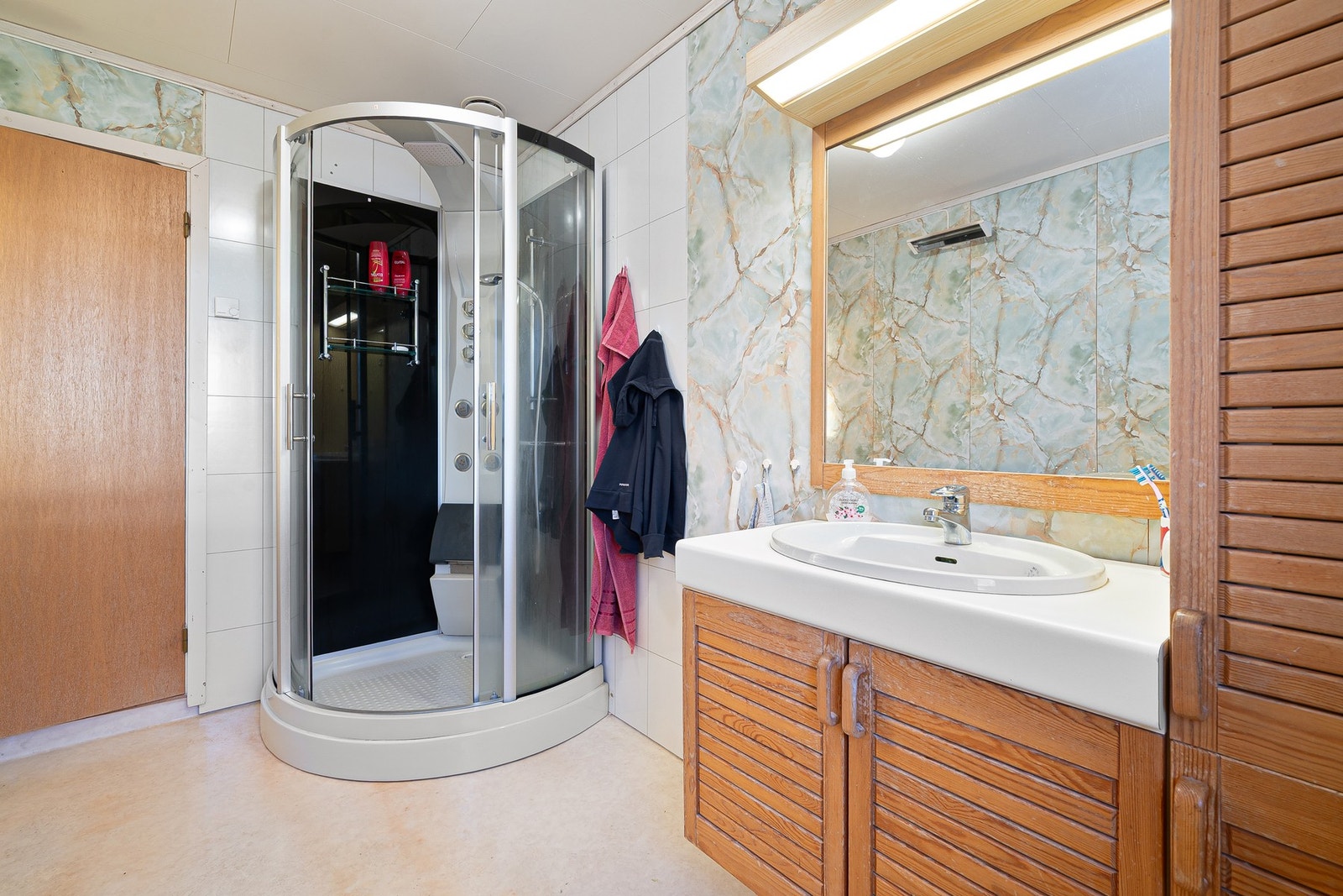 Bad med varmekabler i gulv, dusjkabinett og baderomsinnredning. Galleribilde