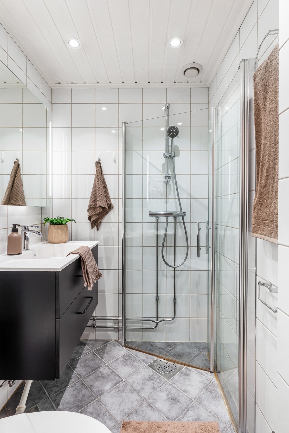 Fra entréen er det adkomst til baderommet. Veggmontert toalett og dusjhjørne med skyvbare glassdører. Galleribilde