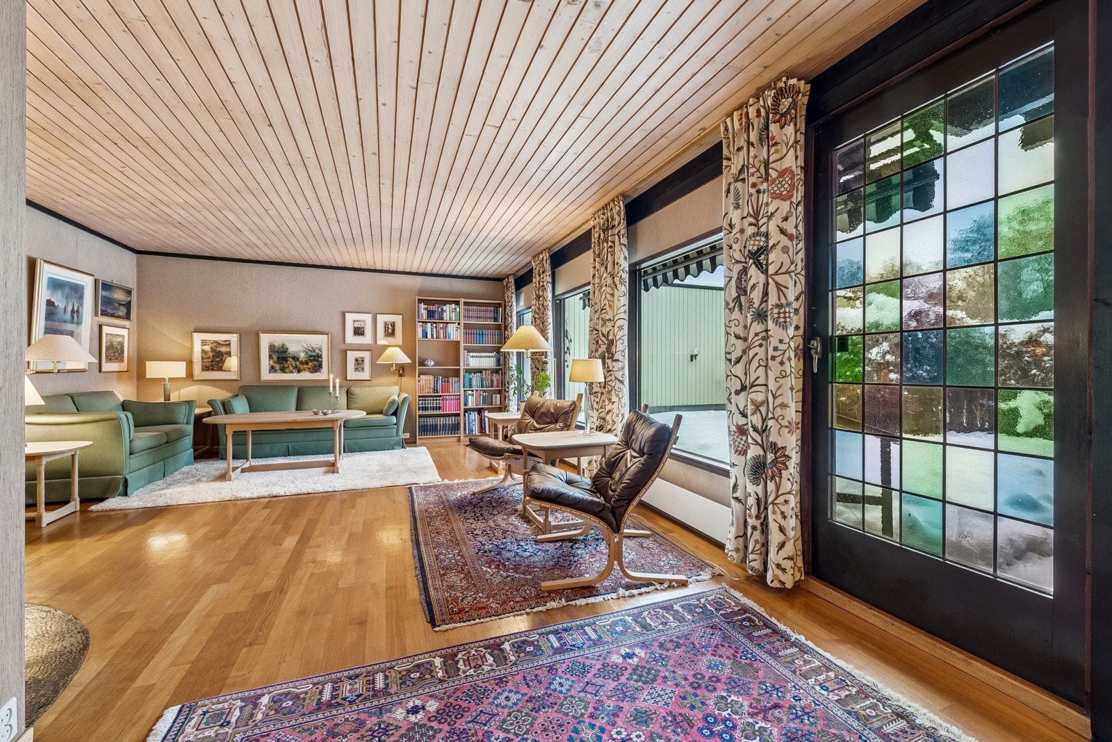 Stue med store vindusflater og dør ut mot atrium. Galleribilde