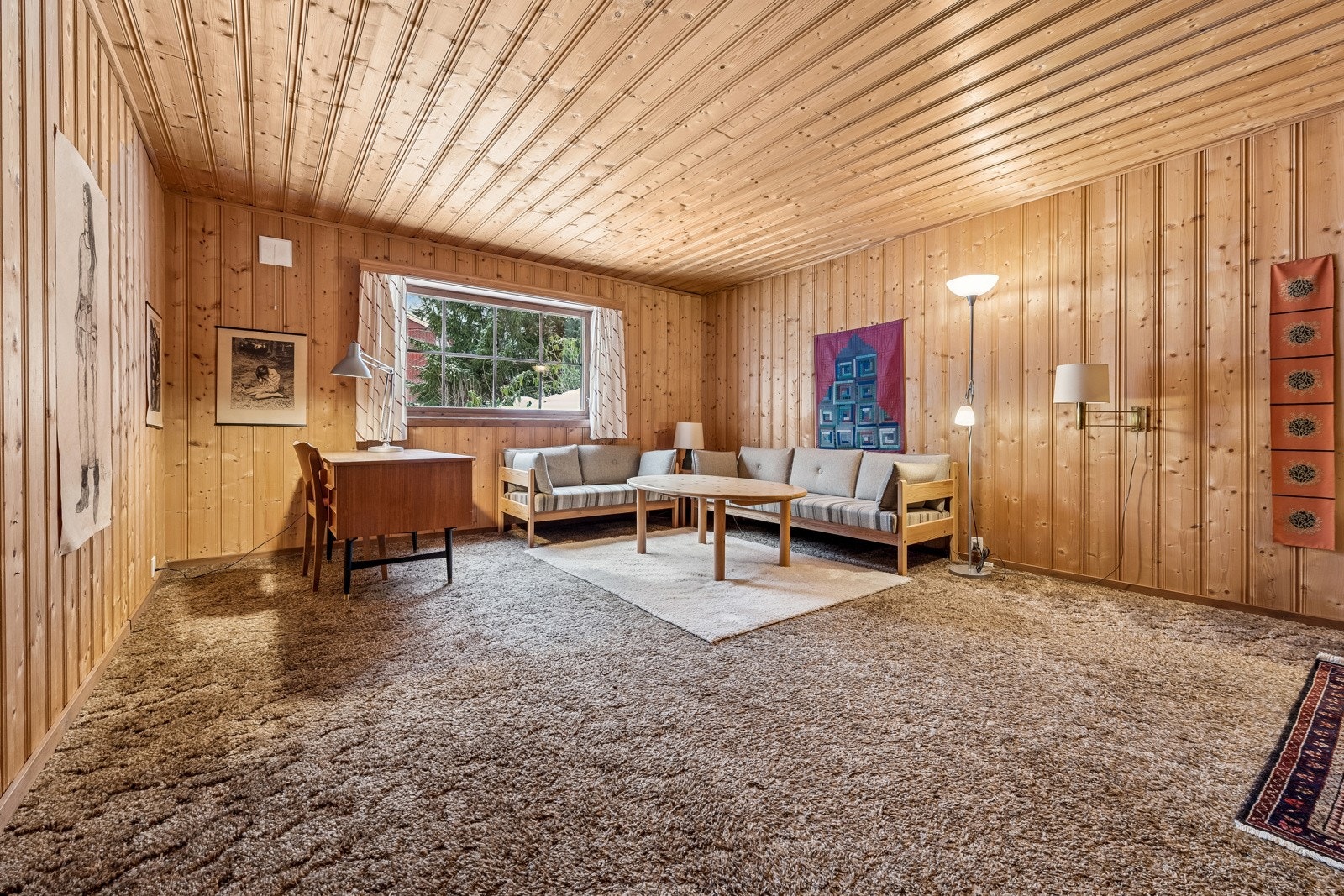 Stuen i kjelleren har stort vindu ut mot "hage", friområde ned mot bekken. Galleribilde