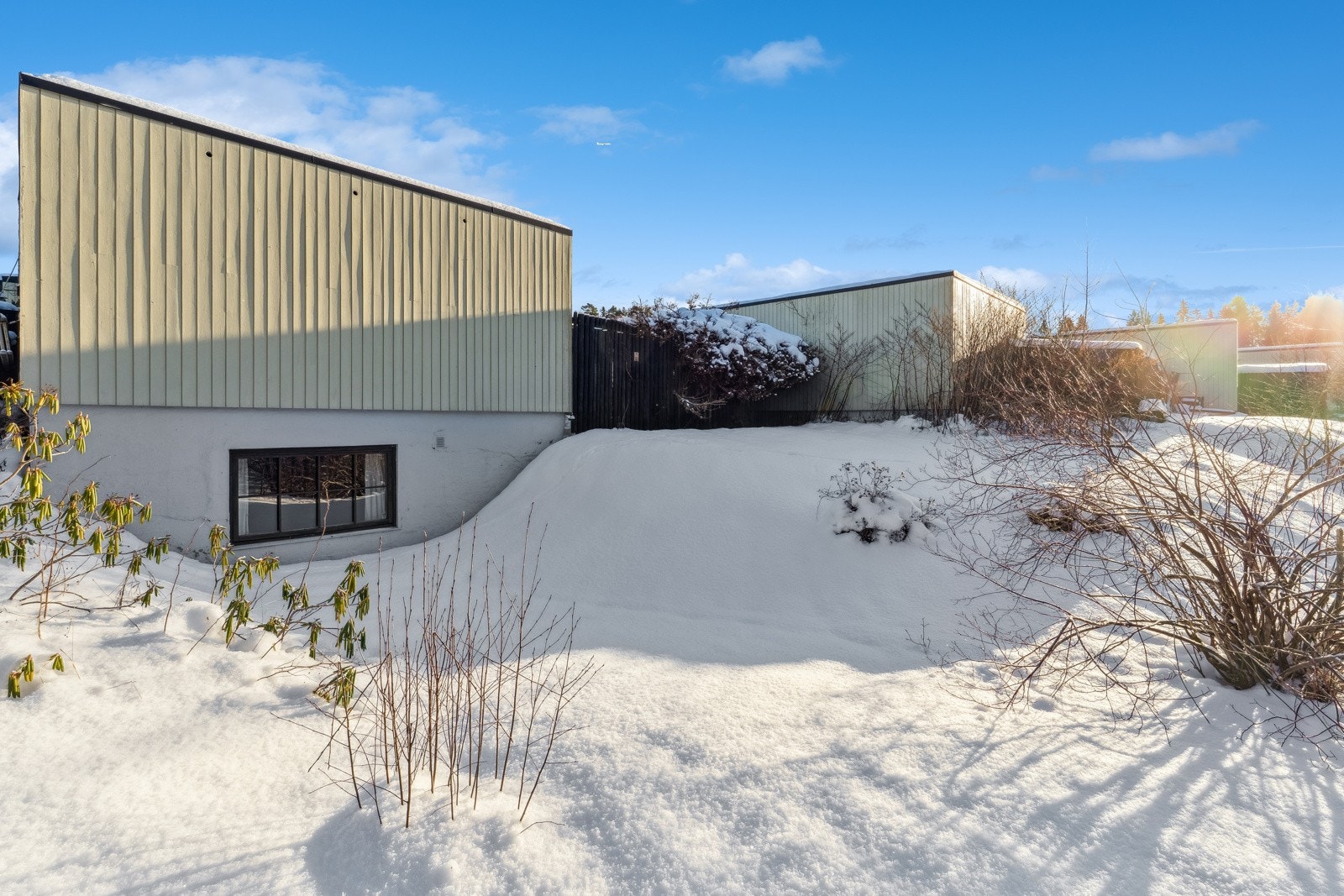 På baksiden av huset, som vender ut mot friområder, pent beplantet med trær og prydbusker. Et lekeeldorado både på sommer og vinterstid. Galleribilde