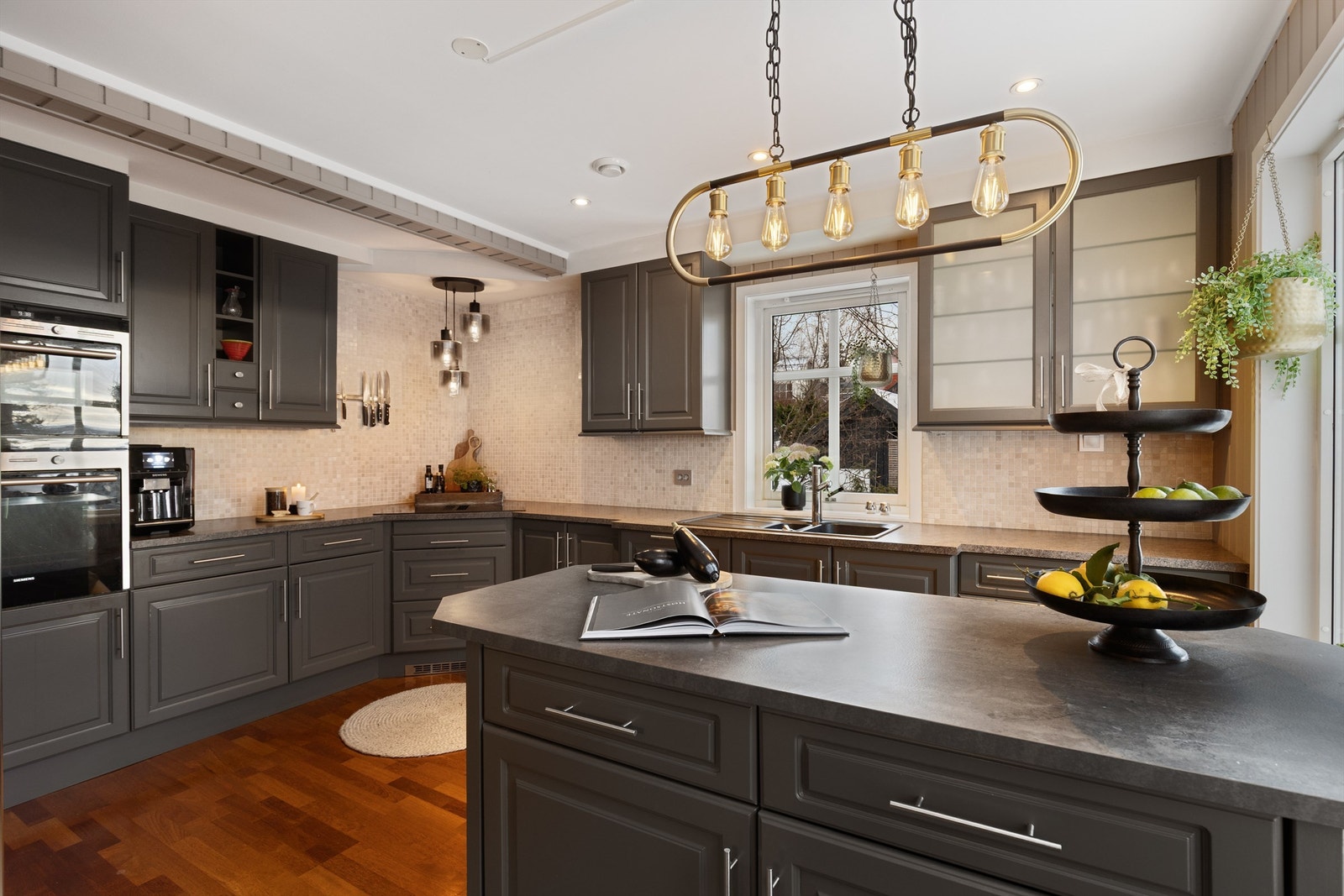 Kjøkken med romslig kjøkkenøy med oppbevaring Galleribilde