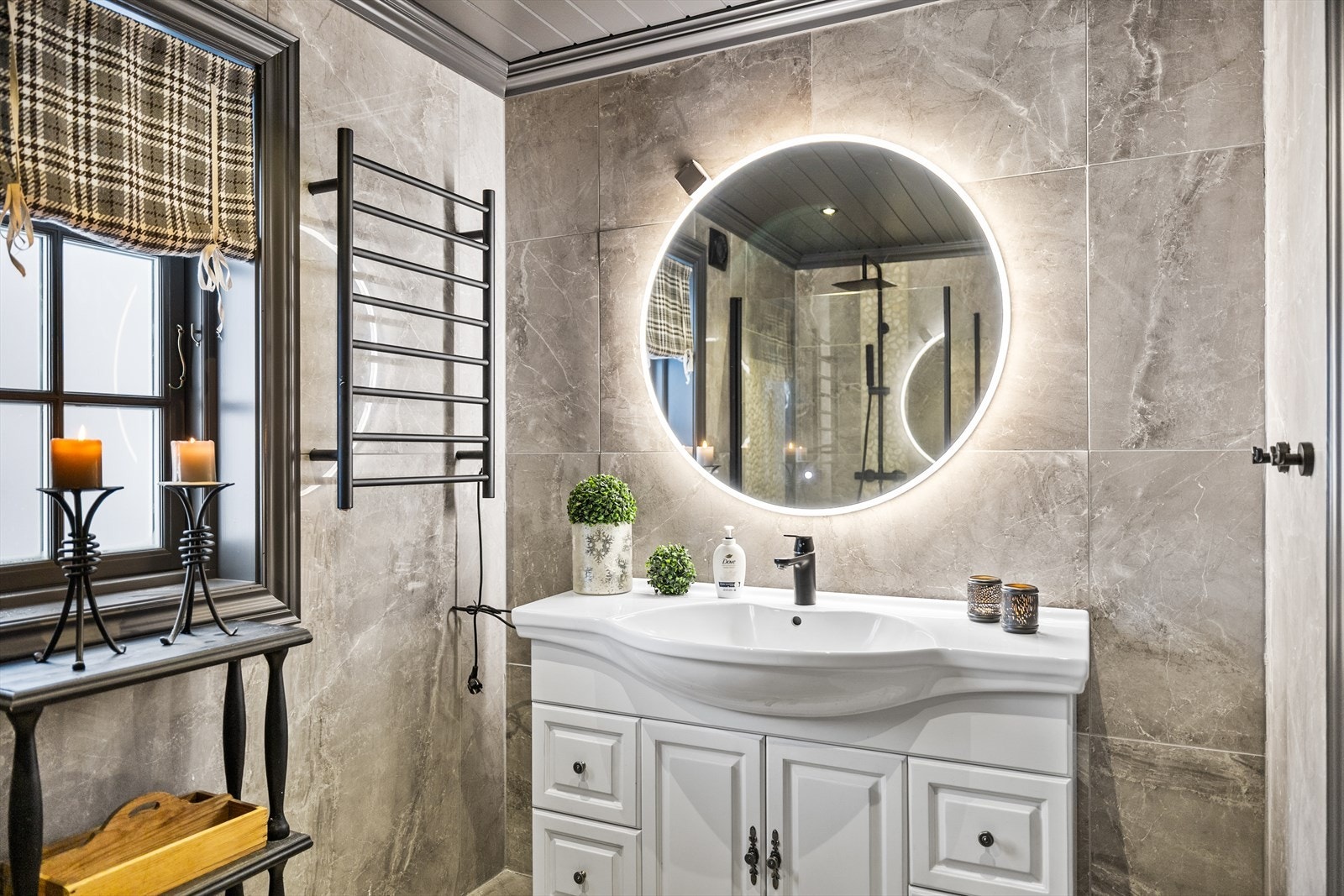 ...og servant i pen innredning med lys speil over. Galleribilde