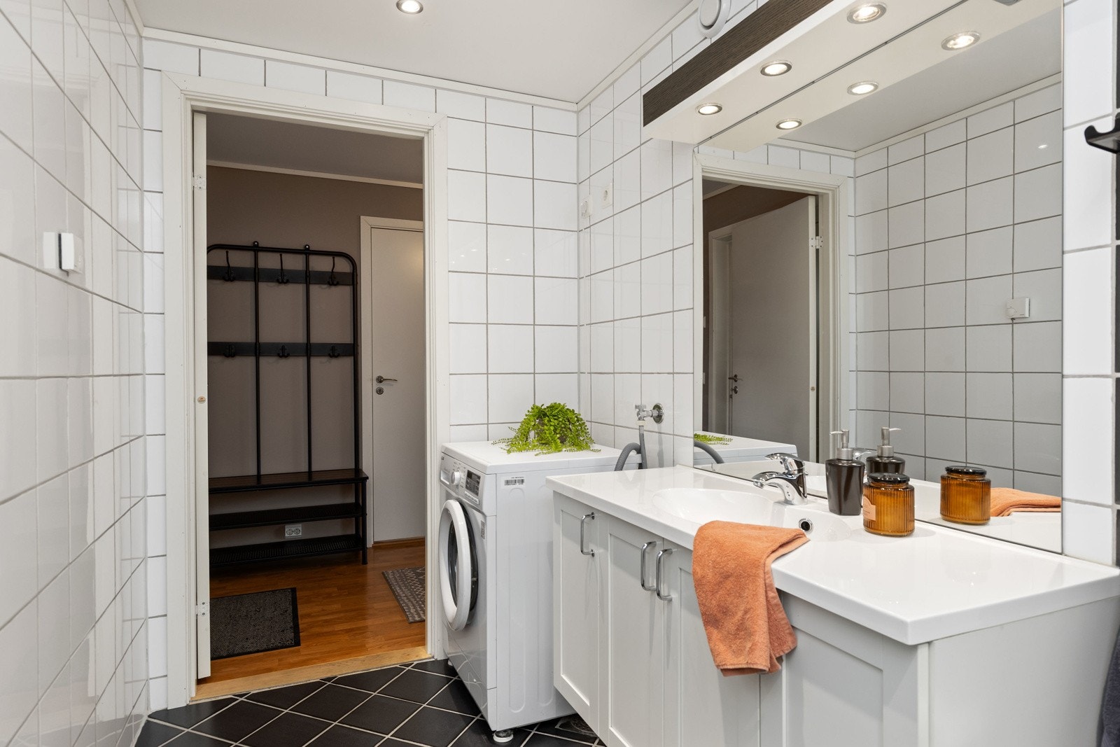 Tidløs hvit innredning og opplegg til vaskemaskin/tørketrommel. Galleribilde