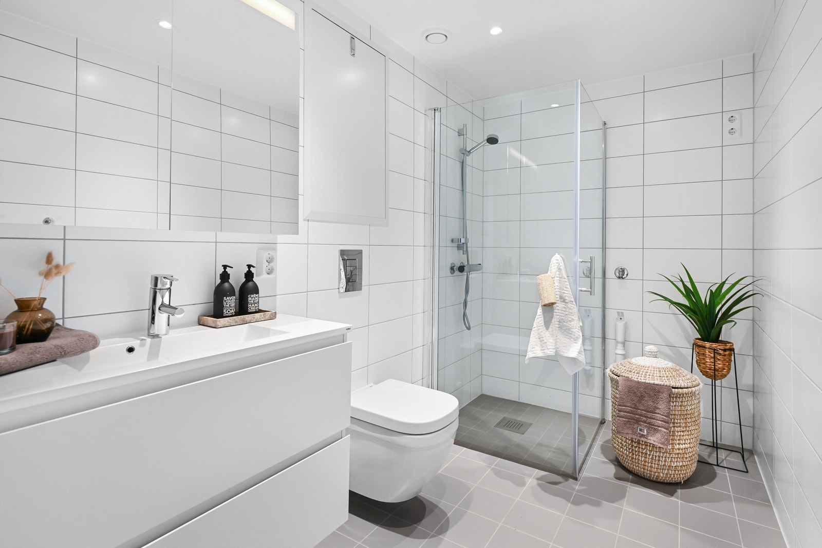 Moderne og romslig helfliset bad med opplegg for vaskemaskin Galleribilde