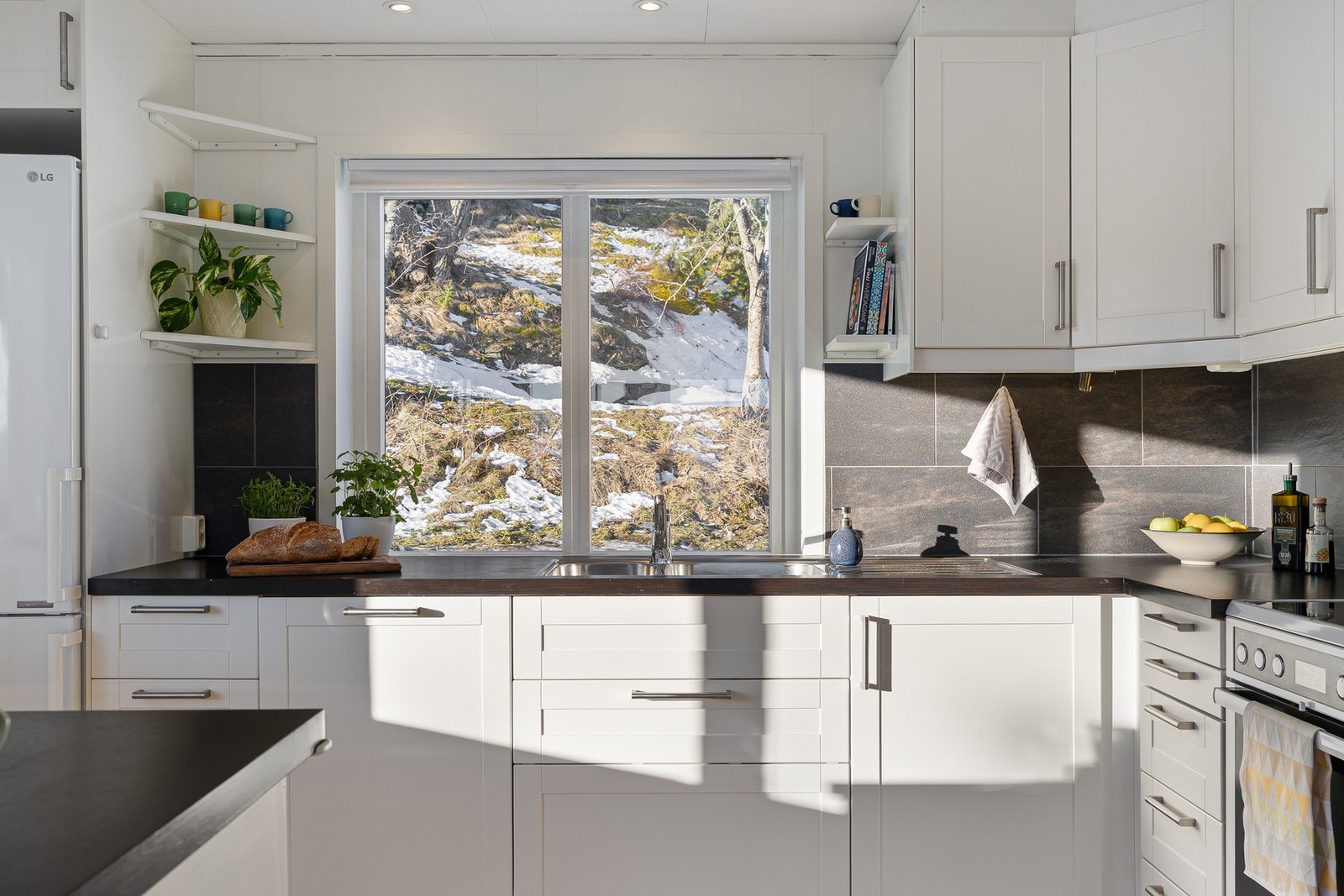 Romslig kjøkken med god lagringsplass og fint utsyn ved benken. Galleribilde