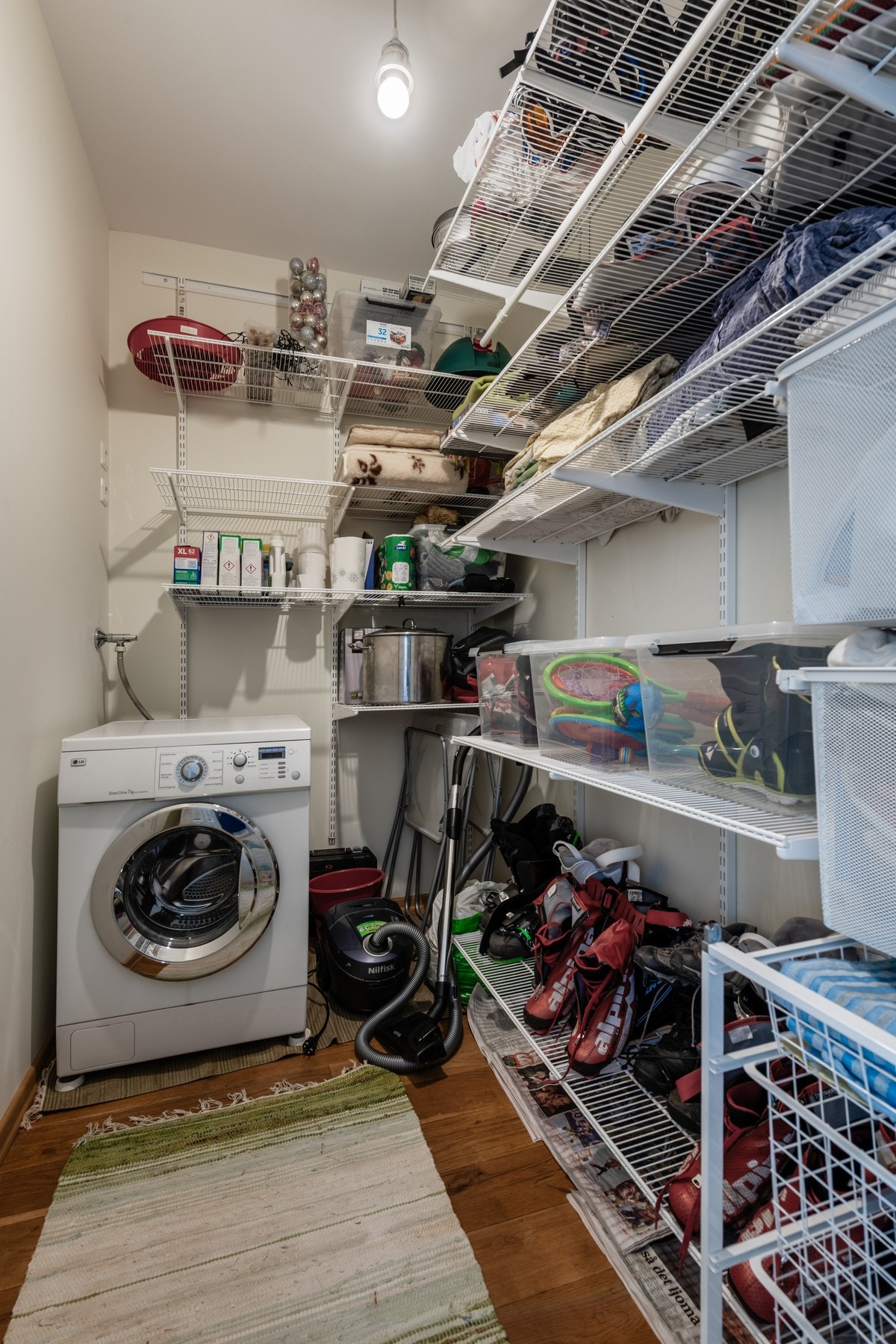 Bod innredet med praktisk oppbevaringsløsning og opplegg for vaskemaskin Galleribilde