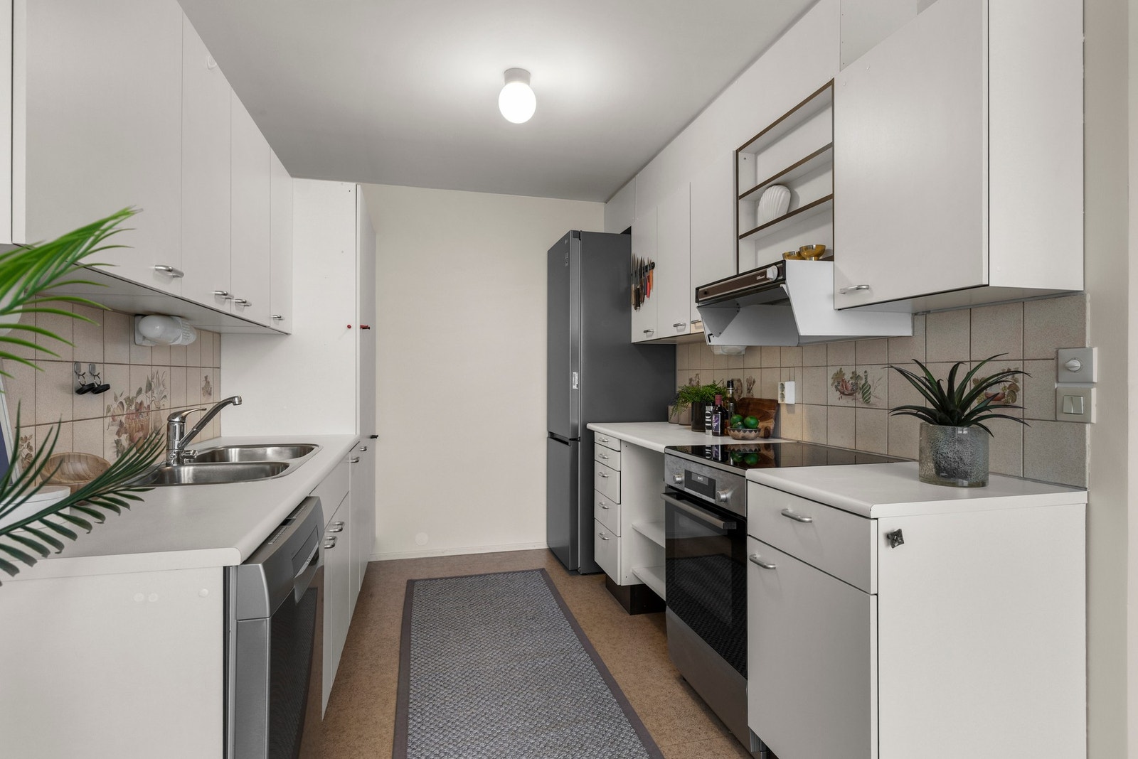 Her er det bra med benkeplass og gode oppbevaringsmuligheter i over- og underskap. Det er laminat benkelate med nedfelt oppvaskkum samt fliser over kjøkkenbenken. Galleribilde