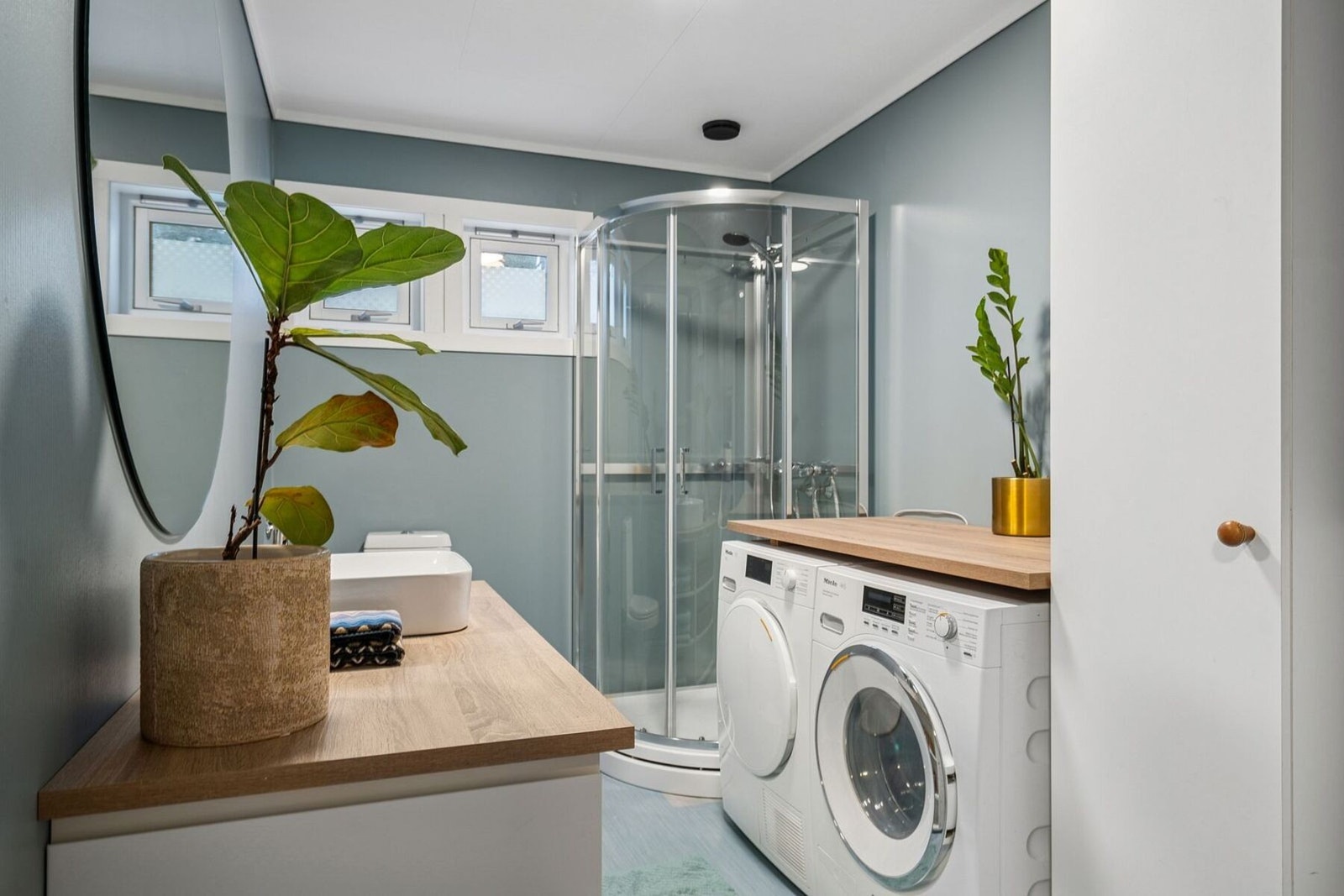 Her er det plass til både vaskemaskin og tørketrommel og benkeplate til å brette tøy. Galleribilde