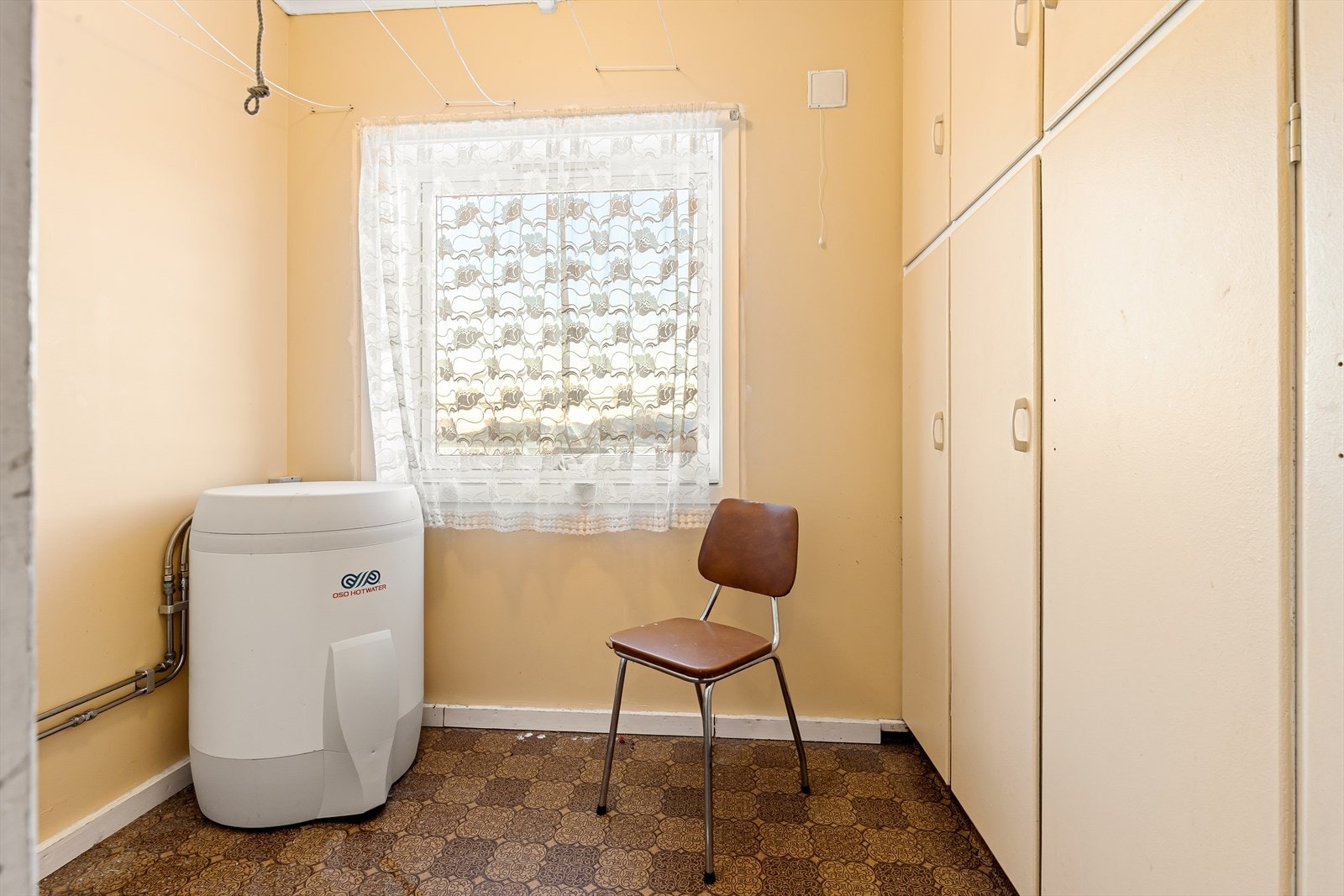 Praktisk vaskerom med belegg på gulv, malte veggplater og standard himlingsplater.Inneholder opplegg for vaskemaskin. Galleribilde