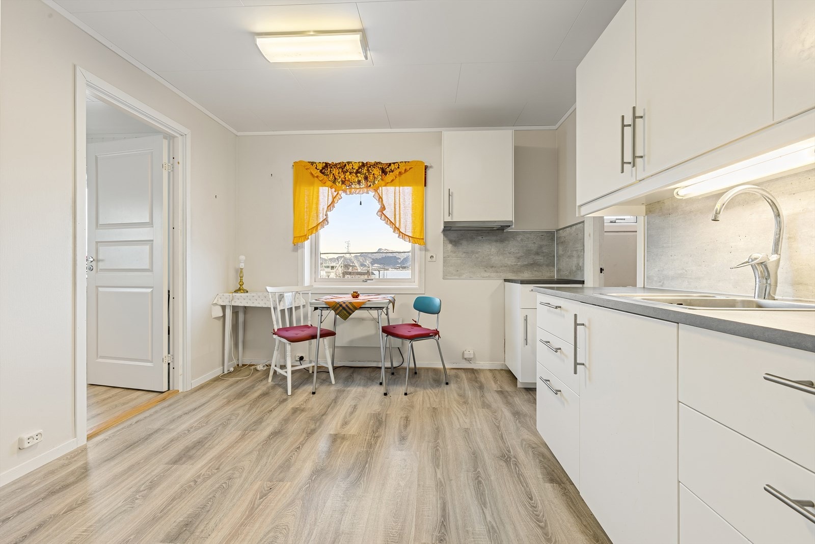 Kjøkkeninnredning fra nyere tid med glatte fronter og laminat benkeplate Galleribilde