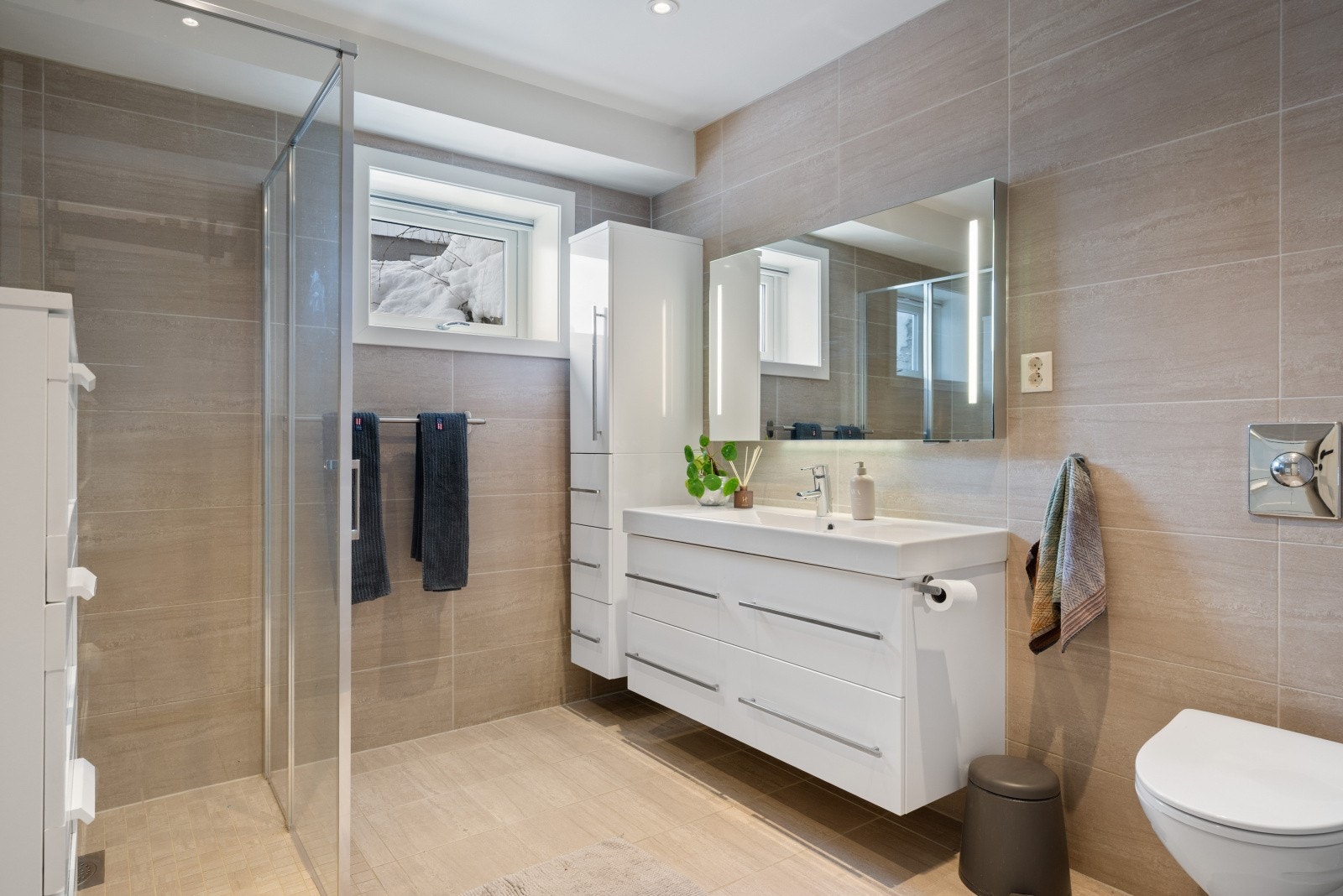 I underetasjen finner du også et romslig, flislagt baderom innredet med dusjnisje med glassdører, servantinnredning og toalett. Galleribilde