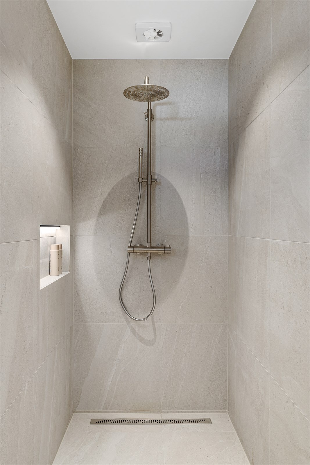 Delikate fliser og gjennomførte detaljer gir rommet et eksklusivt preg. Elektrisk styrt ventilasjon og tilluft via dør sørger for god luftkvalitet. Dette badet må oppleves! Galleribilde