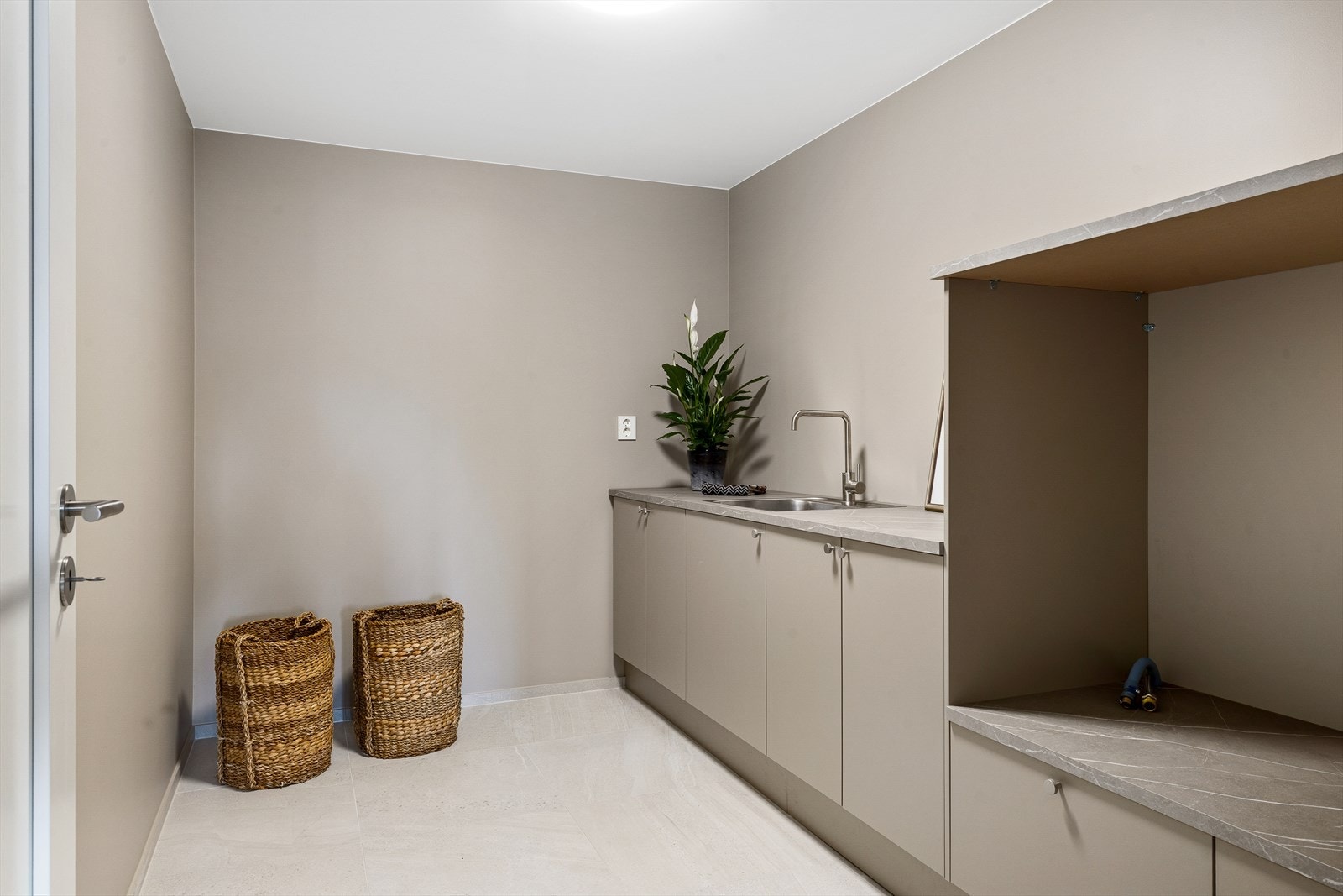 Lekkert og funksjonelt vaskerom fra 2024 - helt nytt og ikke tatt i bruk. Rommet er stilrent innredet med flislagt gulv og elektriske varmekabler som gir en lun og behagelig opplevelse året rundt. Galleribilde