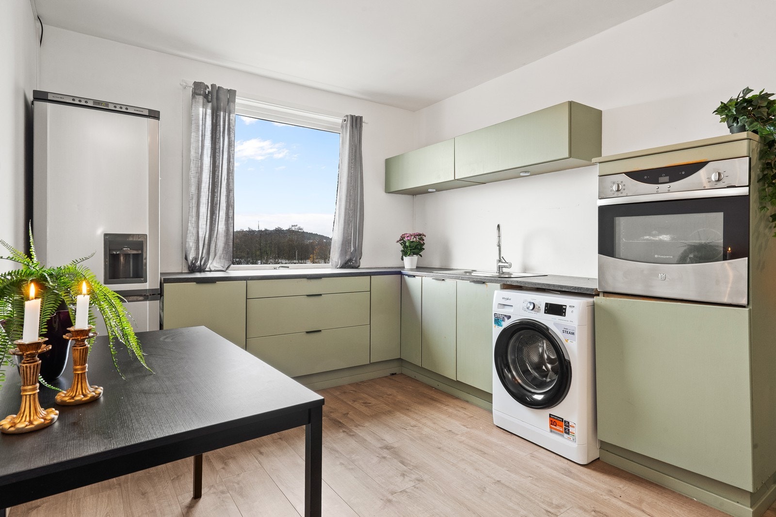 Kjøkkeninnredningen har slette fronter, gode arbeidsflater og opplegg for vaskemaskin. Galleribilde