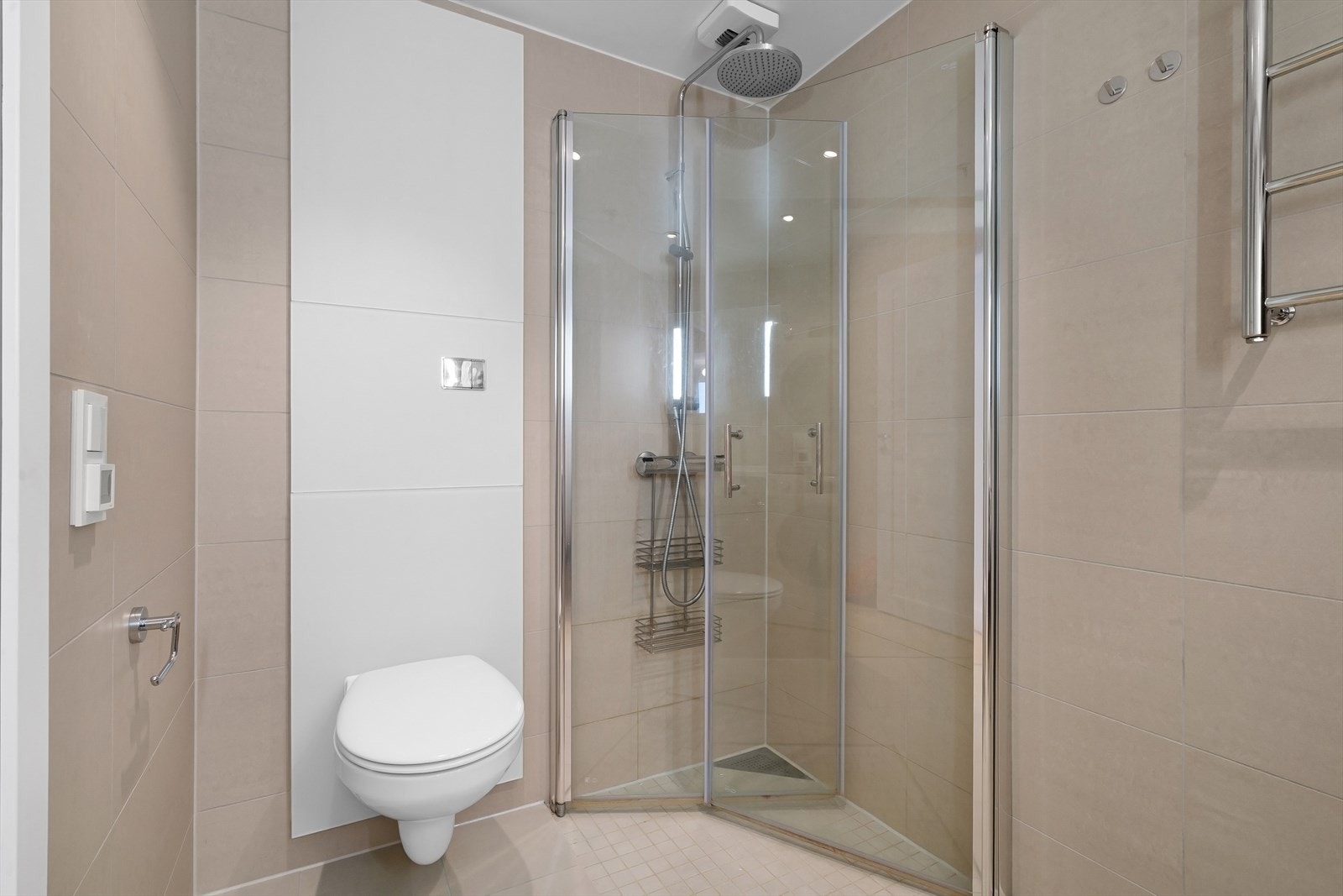 Vegghengt toalett og romslig dusjsone. Elektrisk håndkletørker på vegg. Galleribilde