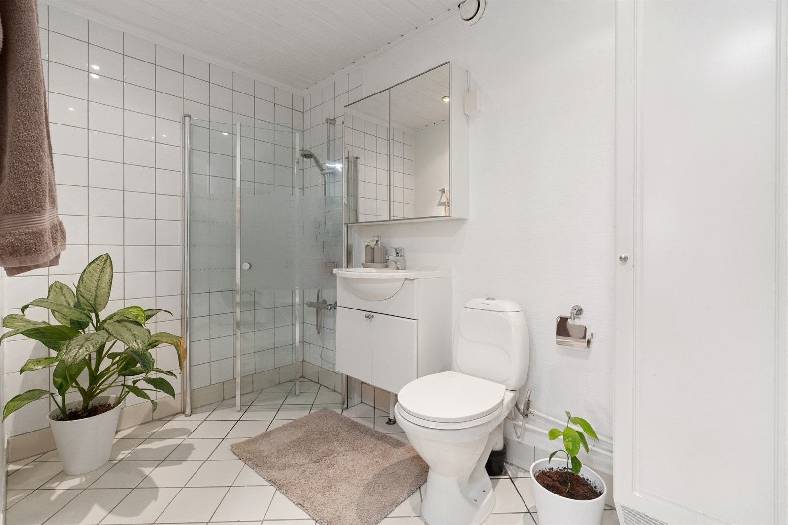 Badet har flislagt gulv, mens veggene har en kombinasjon av fliser og malte flater. Taket er malt. Galleribilde