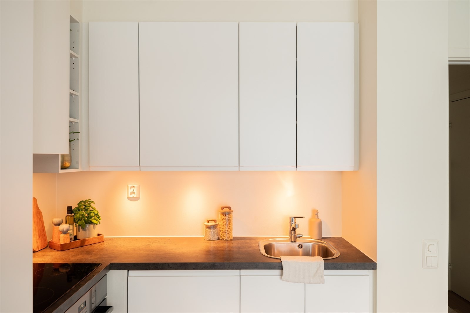 Kjøkkenet har integrerte hvitevarer som kjøleskap, oppvaskmaskin, platetopp og stekeovn. Galleribilde