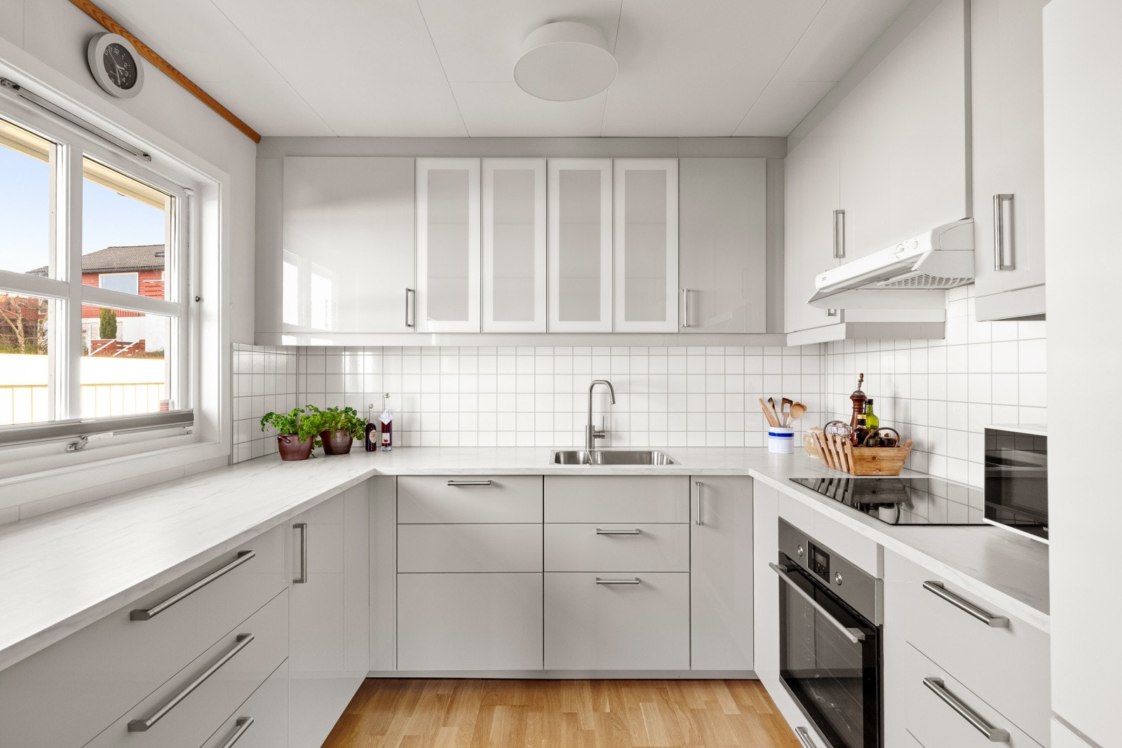 Kjøkkenet er stilrent med hvite slette fronter. Galleribilde