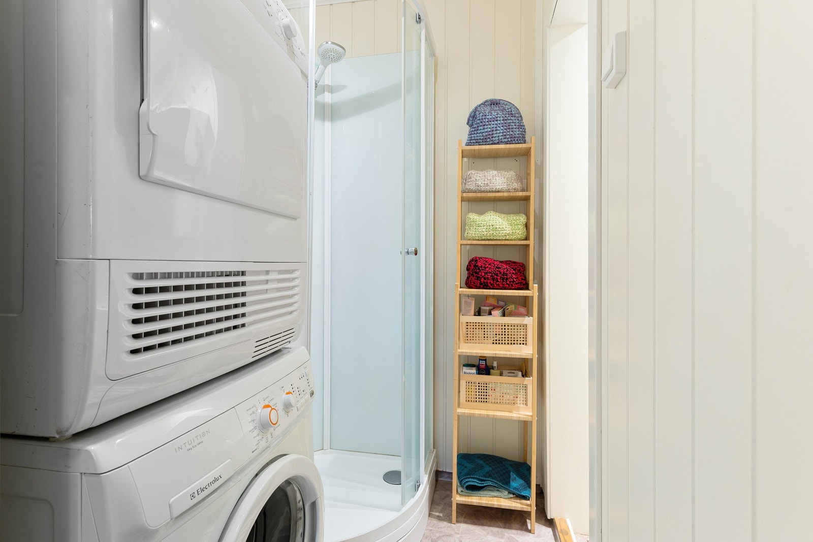 Bad innredet med WC, servant og dusjkabinett med oppsett til vaskemaskin og tørketrommel Galleribilde