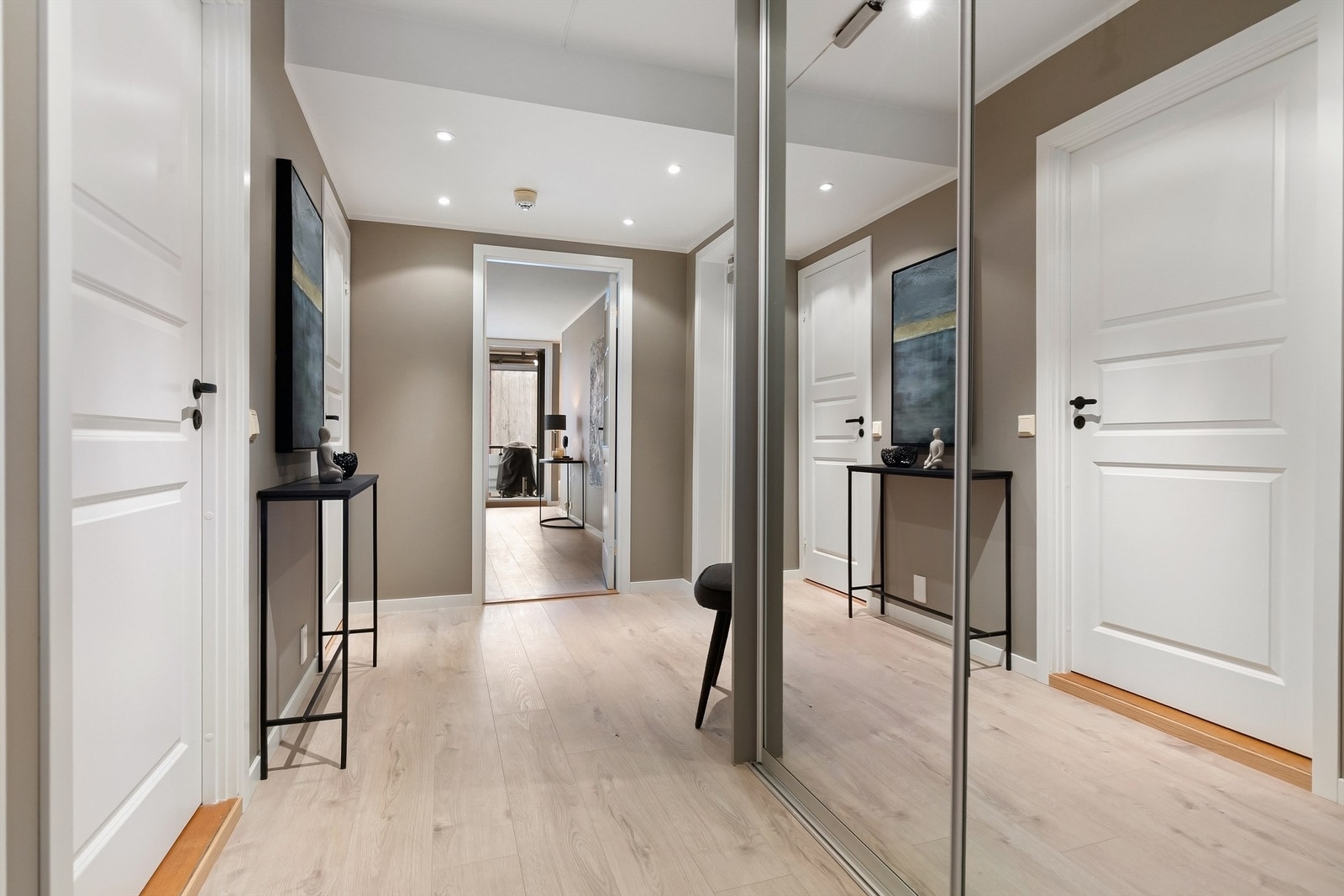 En romslig entré med skyvedørsgarderobe ønsker velkommen. Heis gir adkomst fra garasjeplanet. Galleribilde