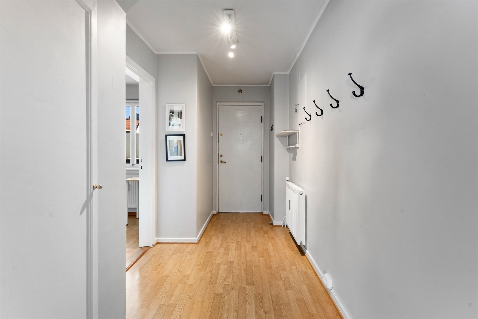 Velkommen inn i en lys entré med plass til å henge fra seg yttertøy. Galleribilde