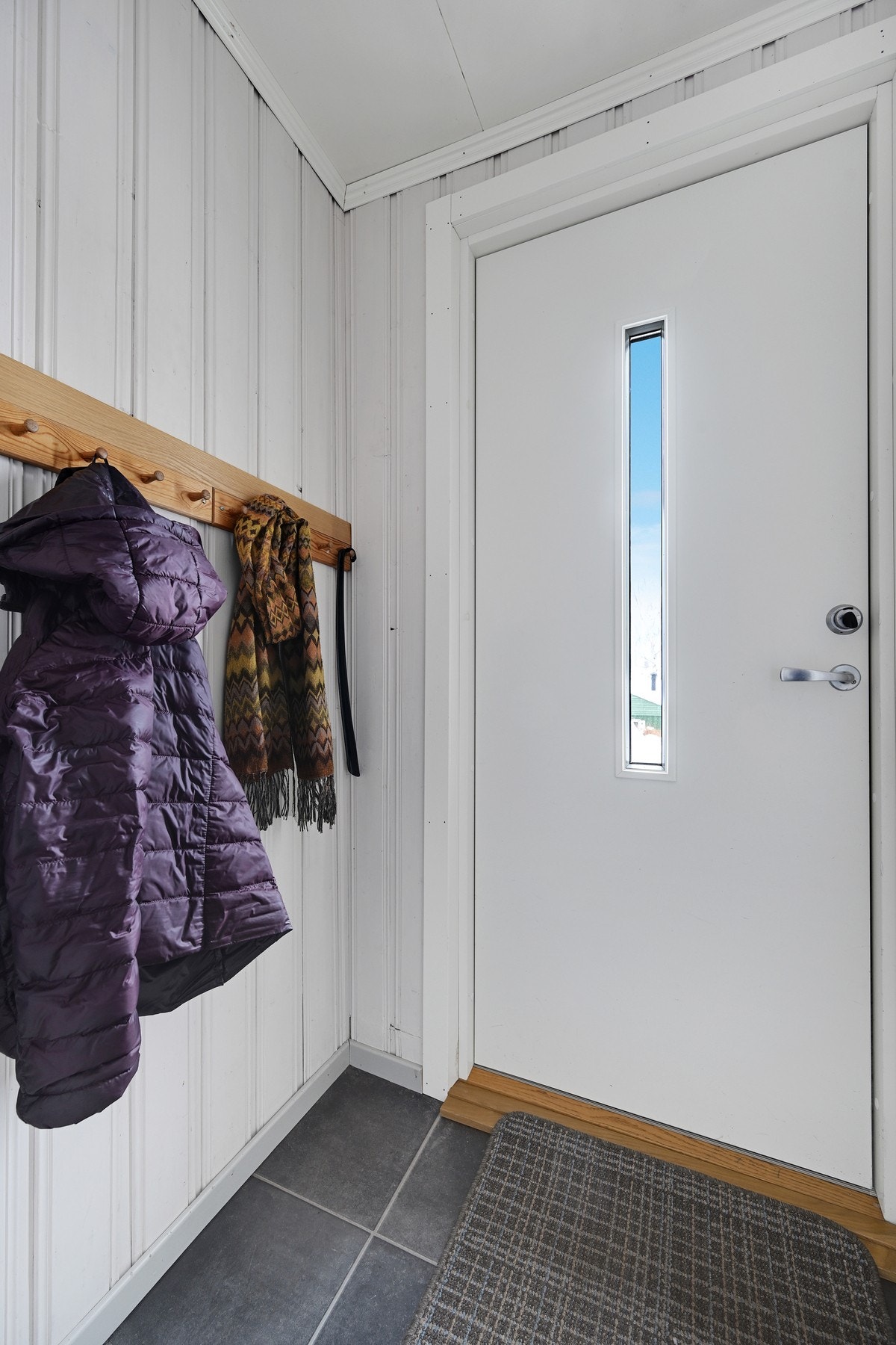 Velkommen inn i en lys entré med plass til å henge fra seg jakken, og sette skoene på plass. Videre har vi gangen med god plass til både klær og sko Galleribilde