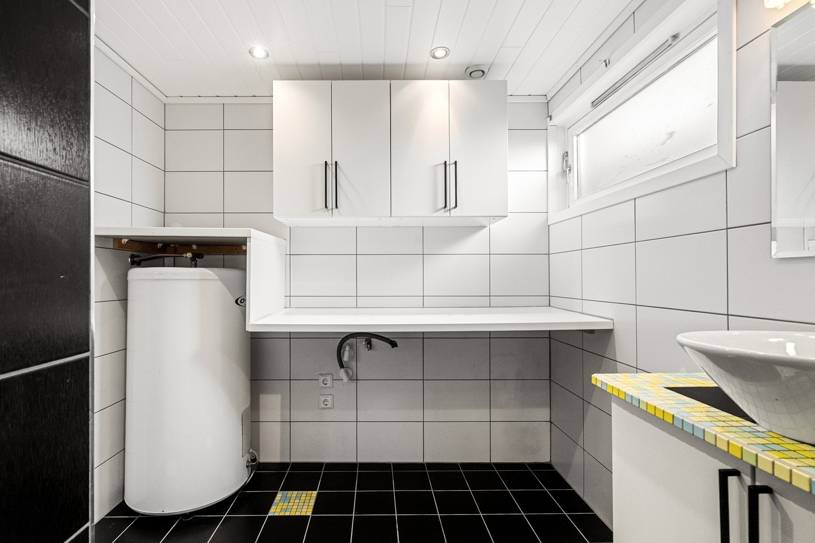 Bad/vaskerom god arbeidsbenk med plass til vaskemaskin. Varmtvannsberederen er plassert på badet. Galleribilde