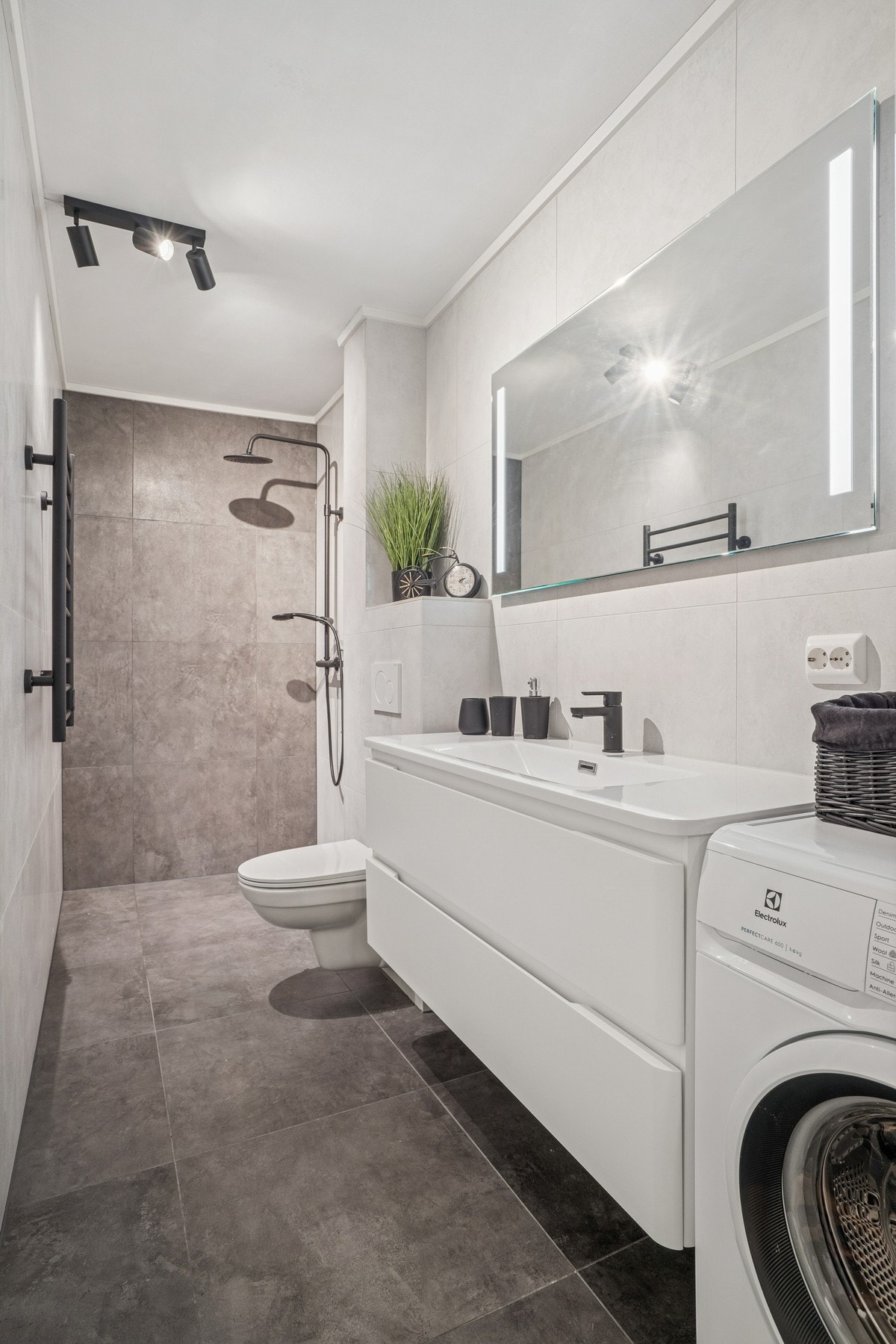 Badet er moderne og påkostet og det er lagt italienske fliser på gulv og vegger. Gulvvarme og uttak for vaskemaskin. Vaskemaskinen medfølger i salget Galleribilde