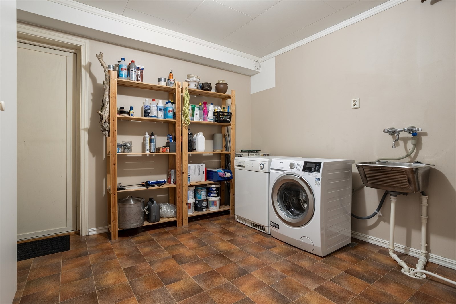Stort vaskerom med skyllekar og opplegg for vaskemaskin/tørketrommel. Herfra er det dør til en uisolert bod med gode lagringsmuligheter. Galleribilde