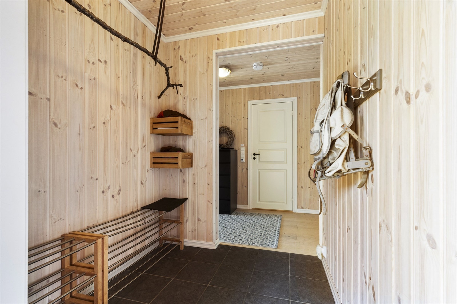 Entré med fliser på gulv, panel på vegger og panel i himling Galleribilde