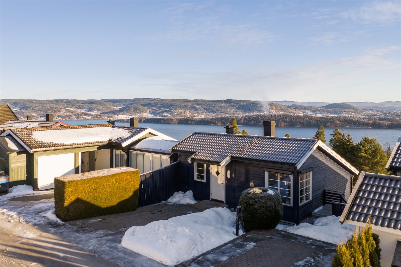 Inngangspartiet til boligen er pent gjennomført og opparbeidet og byr på en særdeles flott steinbelagt gårdsplass med tilhørende parkeringsområde, et hyggelig uteområde og trapp med adkomst til boligens hageområde. Galleribilde