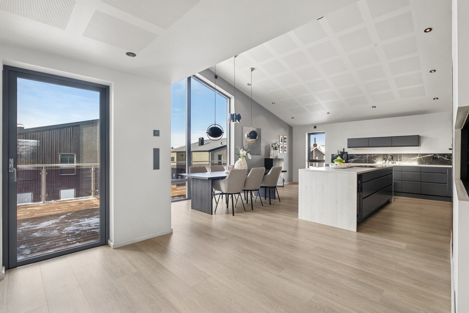 Her finner du et moderne kjøkken med glatte mørke fronter og laminat benkeplate. Galleribilde