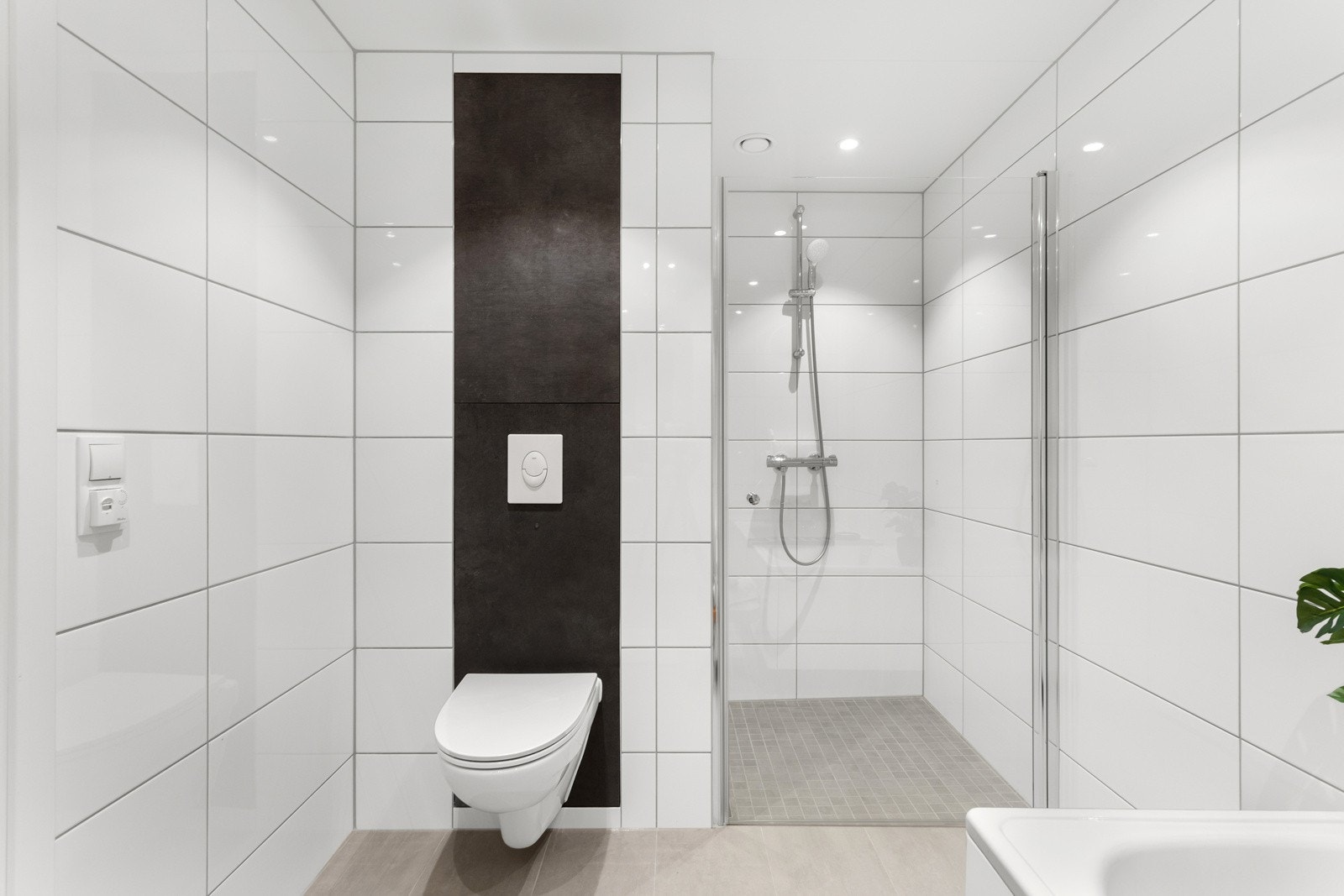 Dette badet er innredet med vegghengt servantinnredning med skuffer, speil, frittstående badekar, dusjhjørne og vegghengt toalett. Galleribilde