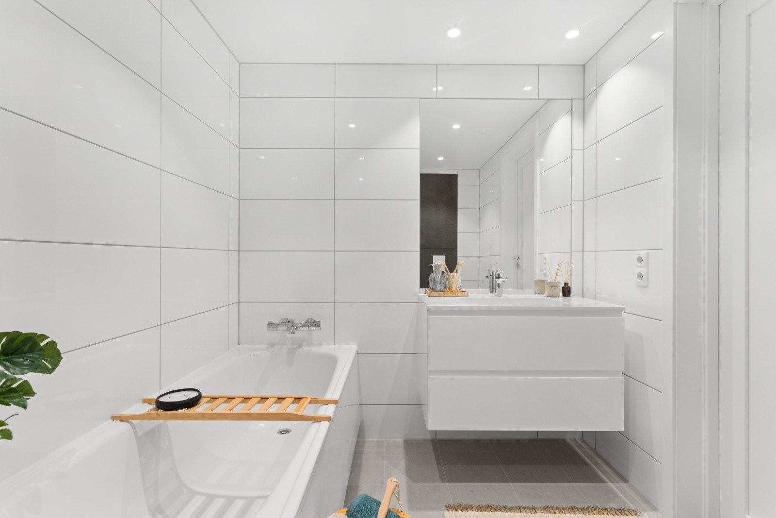 Begge badene har flislagte vegger og gulv, varme i gulvet og nedsenket himling med downlights. Galleribilde