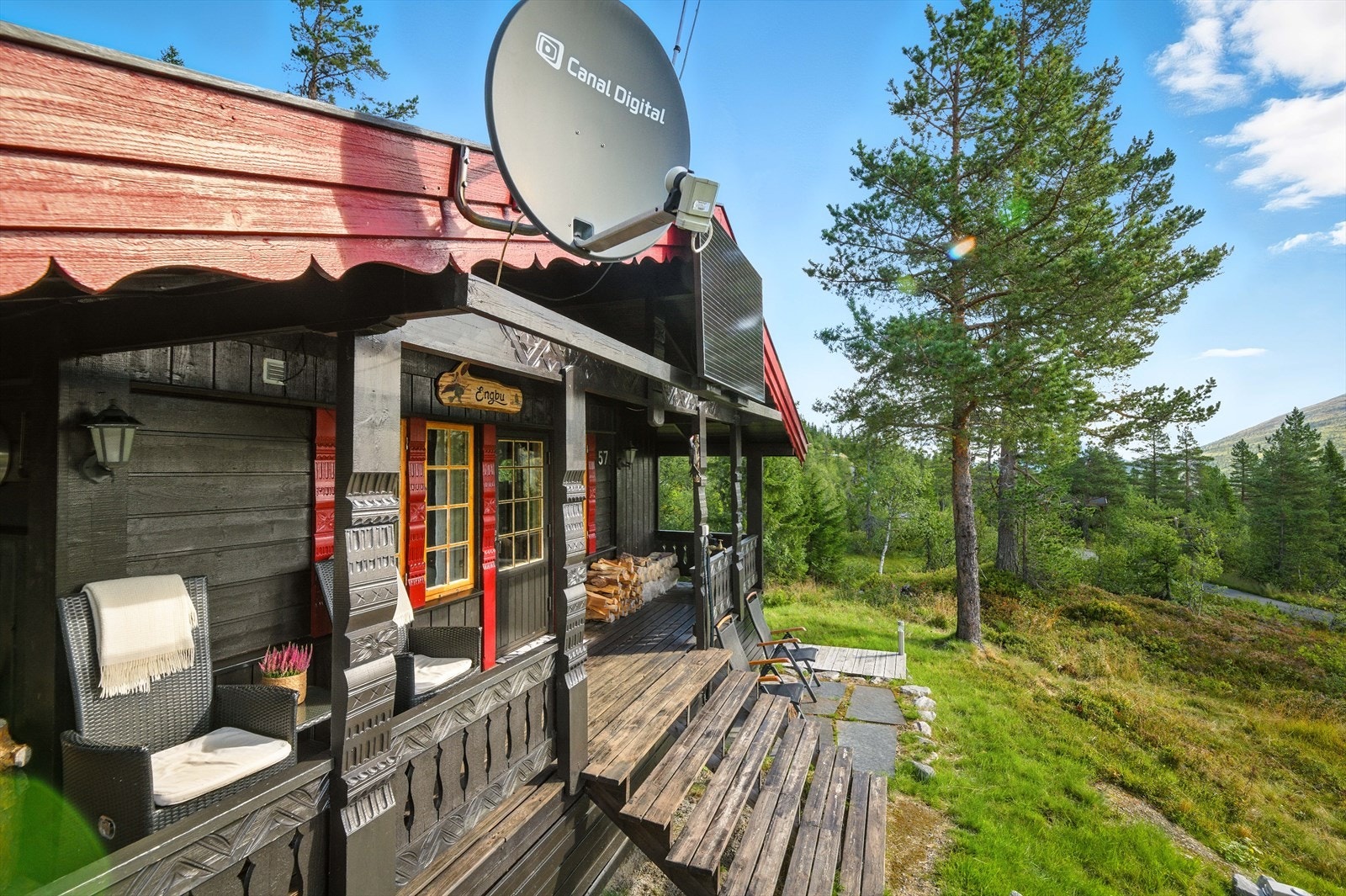 Det er tillaget en uteplass med steinheller foran verandaen og en terrasse langs den ene kortveggen. Galleribilde