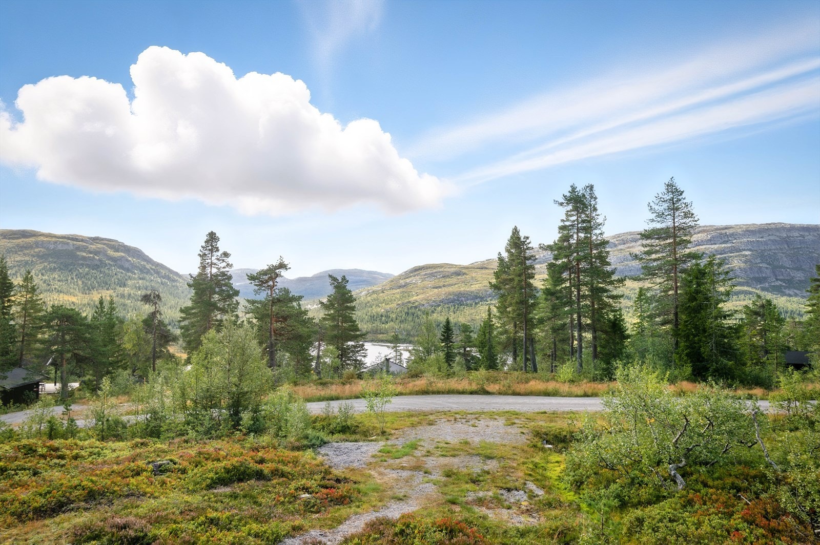 På eiendommen er det også opparbeidet en gruslagt sti fra verandaen og ned til parkeringsplassen. Parkeringsplass nedenfor hytta, ved veien Slåkånuten. Galleribilde