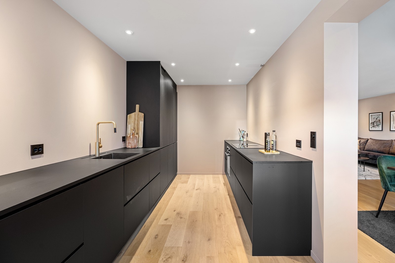 Moderne kjøkken med stor arbeidsbenk og godt med oppbevaring i skap. Galleribilde