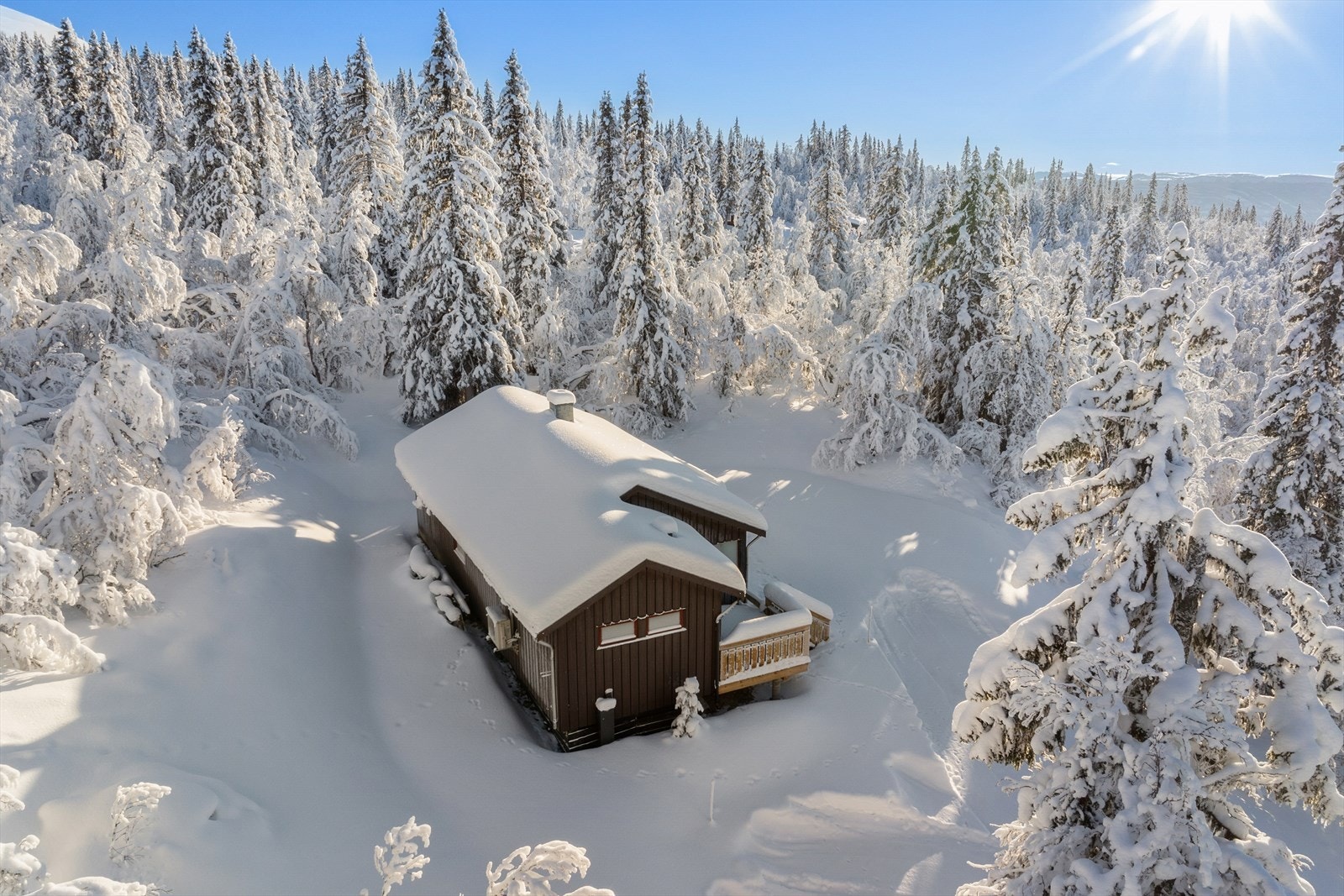 Hytta ligger på toppen av en bakketopp med svært lite innsyn Galleribilde