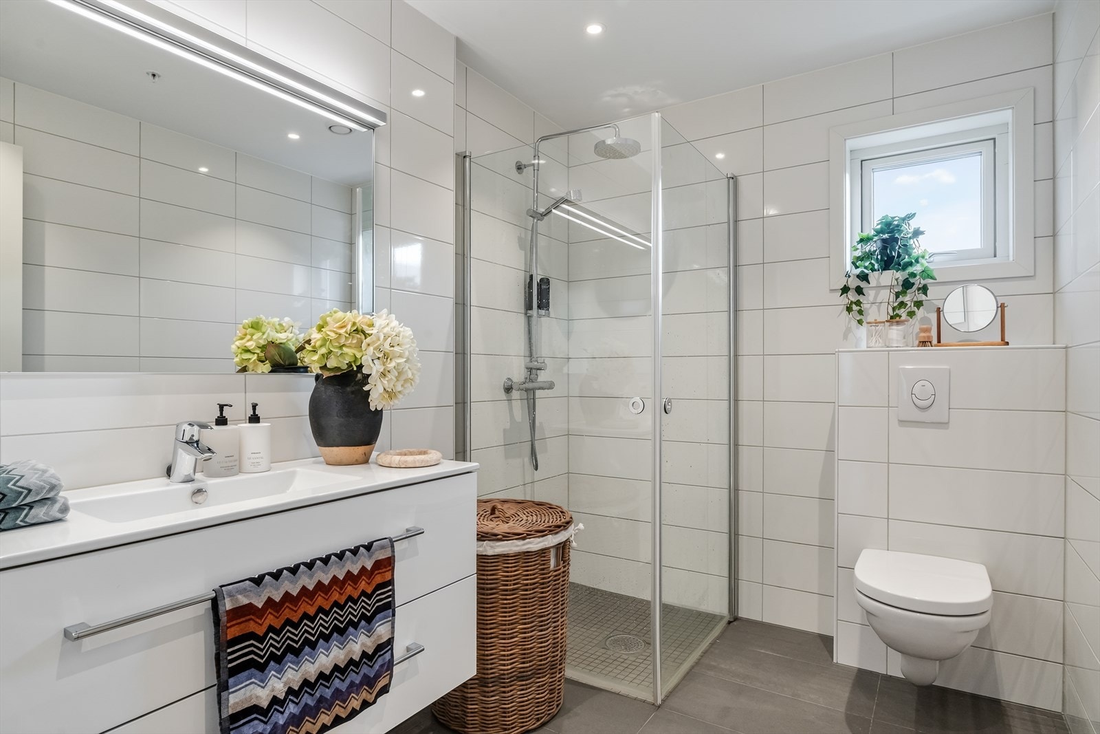 Helfliset bad med gulvvarme, servant med møbel, dusjhjørne og toalett. Balansert ventilasjon. Galleribilde