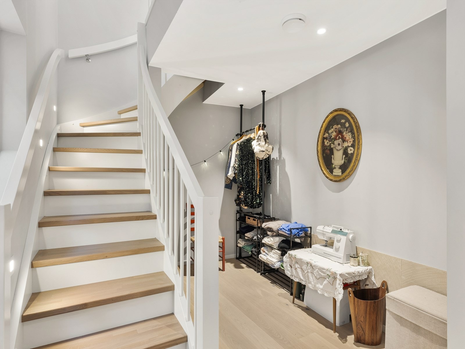 En lys trapp forbinder boligens to plan og her er det satt inn smarte oppbevaringsløsninger. Galleribilde