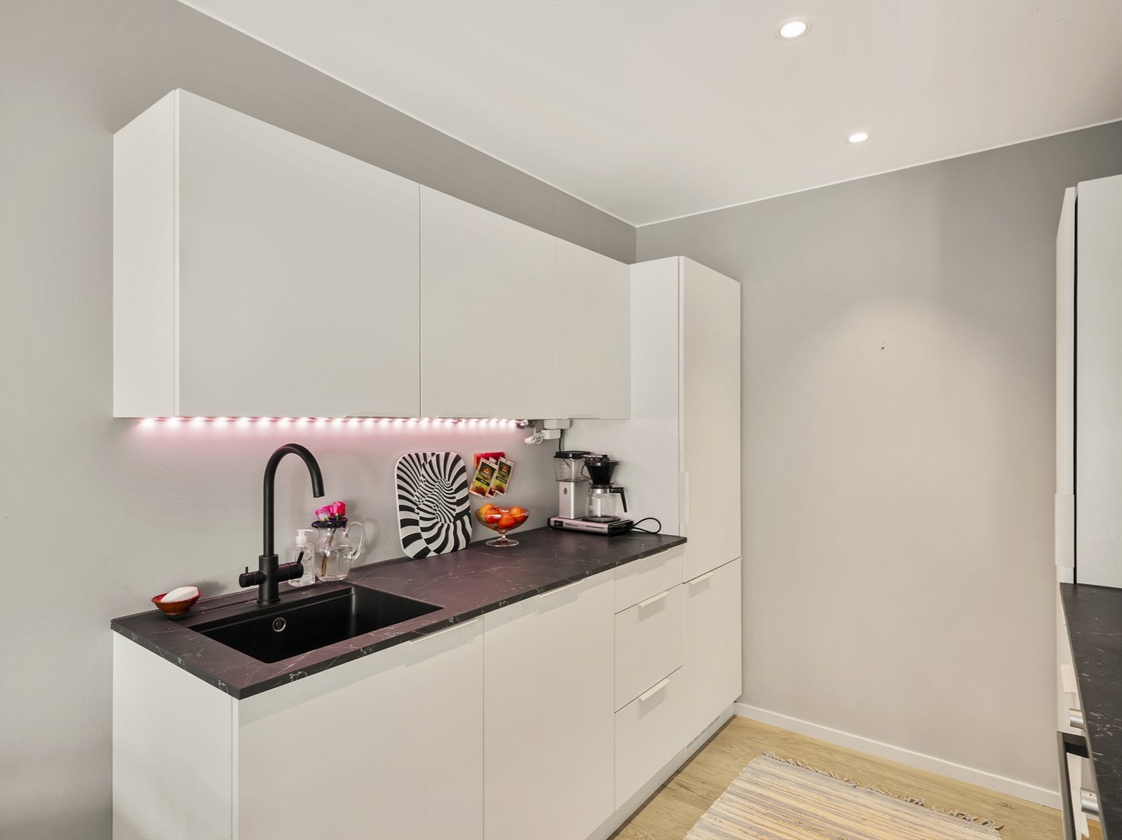 Moderne kjøkken med slette fronter og mørk benkeplate. Galleribilde