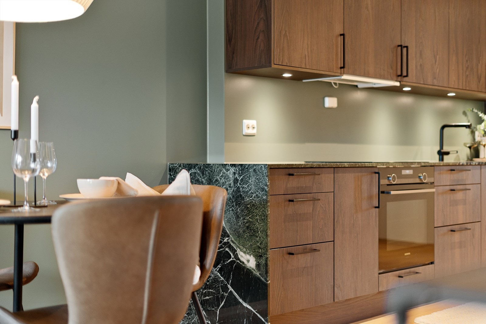 Steinplaten på kjøkkenet har en meget fin avslutning mot stuen hvor den går ned langs siden. Spotter under overskap kjøkken Galleribilde