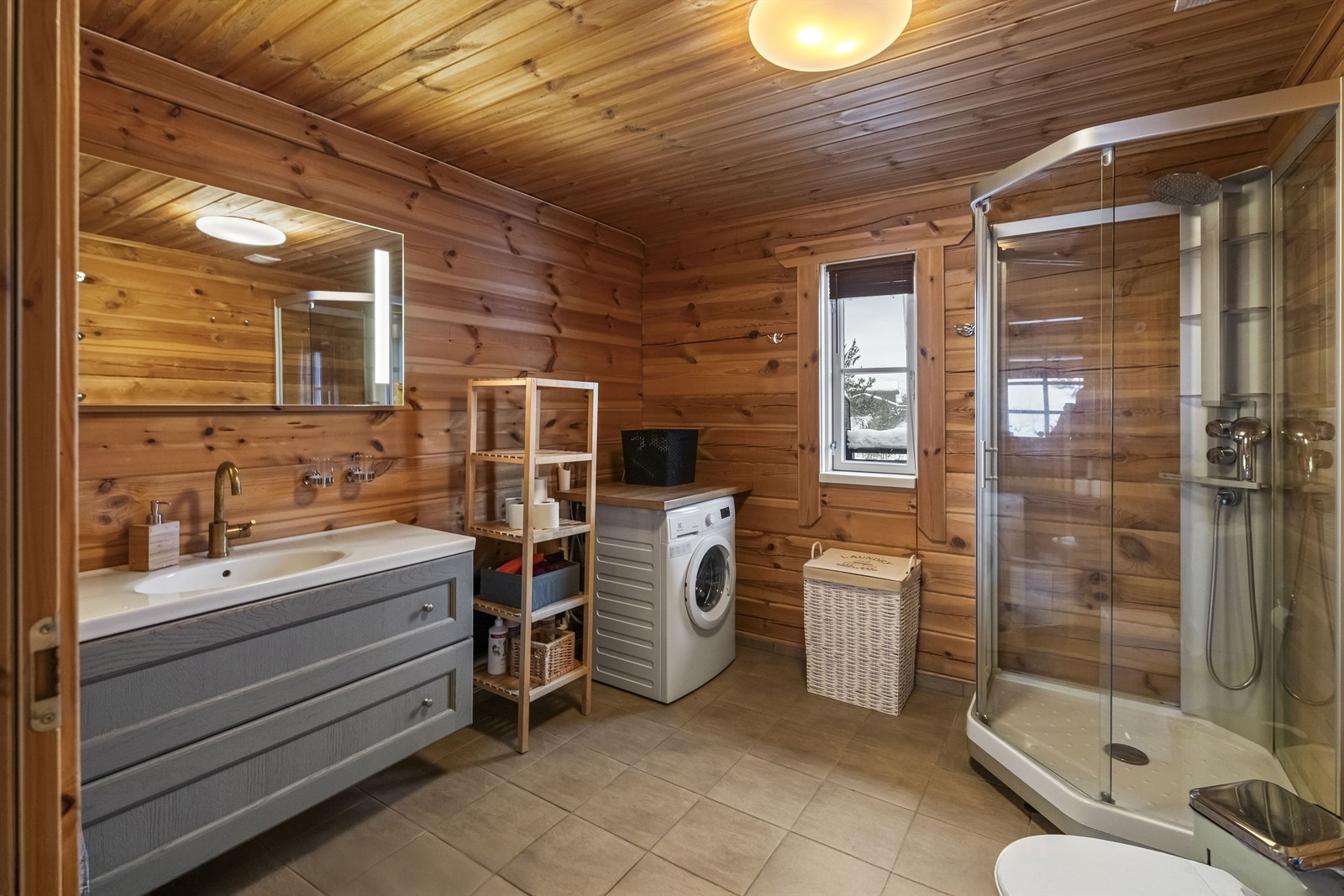 Bad i 1. etasje med dusjkabinett, opplegg til vaskemaskin, wc og servant med skuffeinnredning Galleribilde