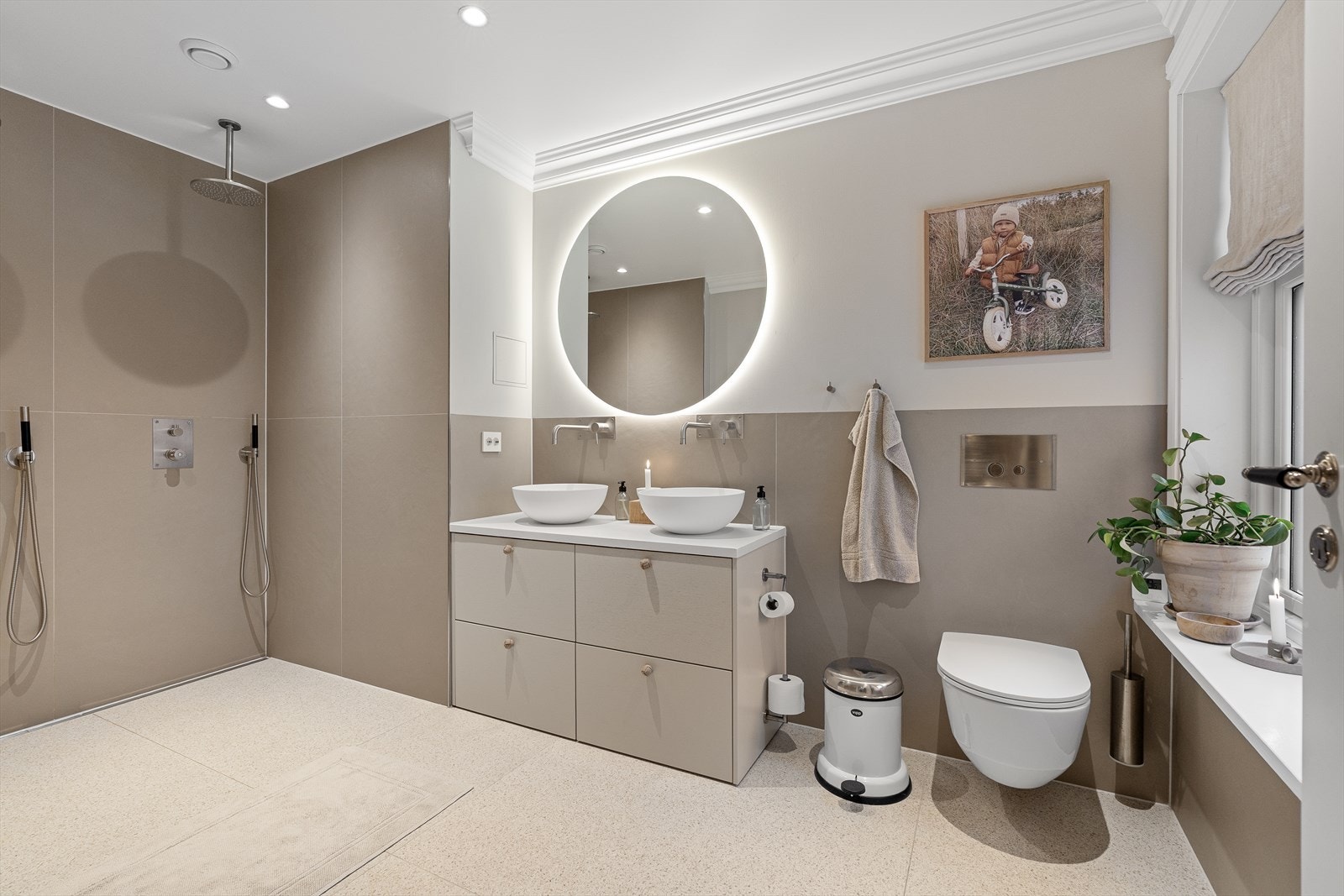 Badet har lekre, store 120x120 terrazzoflis på gulvet og i dusjsonen. Her finner du et vegghengt toalett, dobbel vask med vegghengte armaturer, samt dobbel dusj! Det er gjennomgående armaturer fra Tapwell i børstet nikkel foruten kran på vaskerom Galleribilde