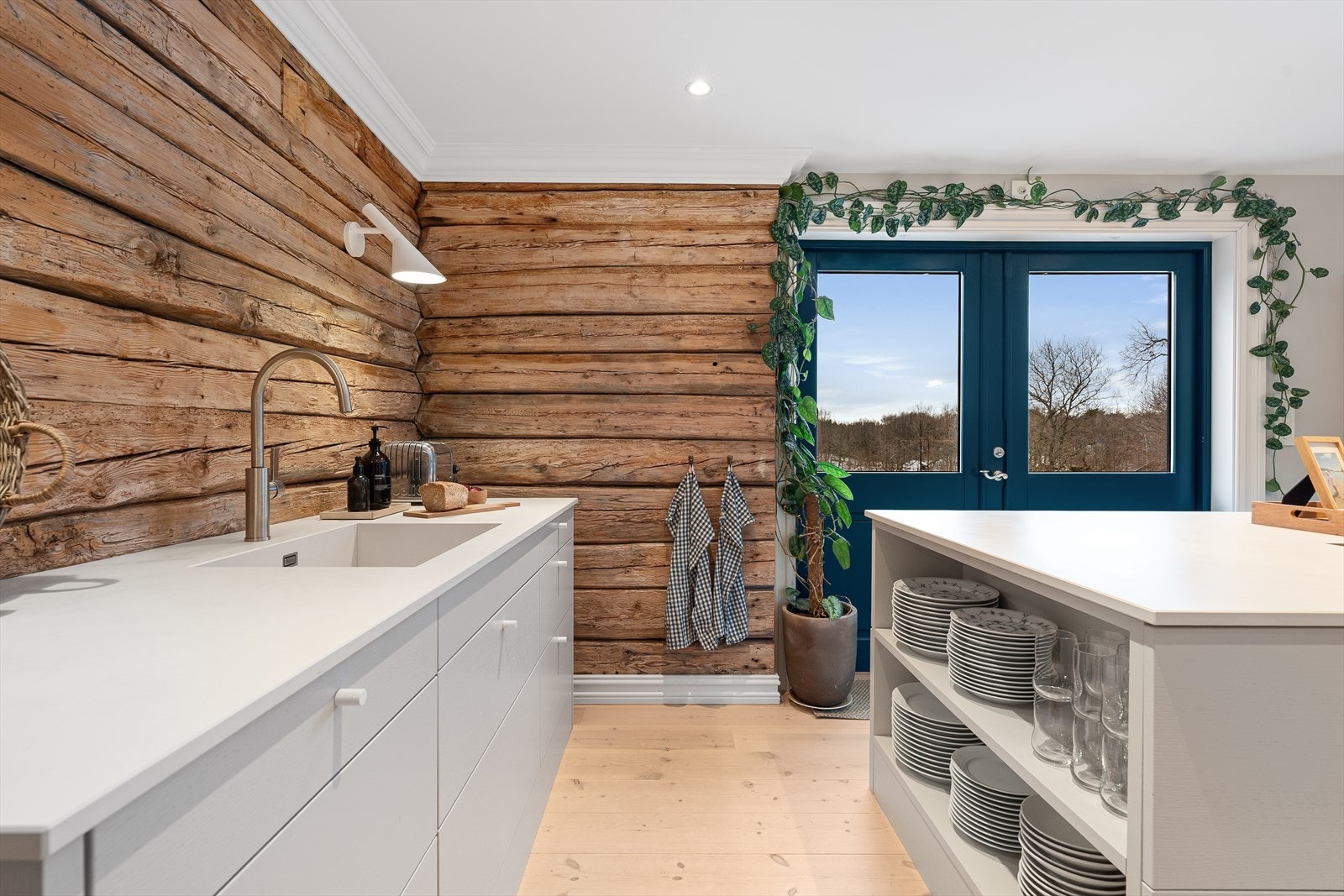 Legg merke til hyllen i enden av kjøkkenøya som er svært praktisk! Den er spesialbestilt og rommer plass til tallerkener og glass (tåler tung vekt) - helt skjult for gjestene ved spisebordet, men lett tilgjengelig i det daglige. Galleribilde