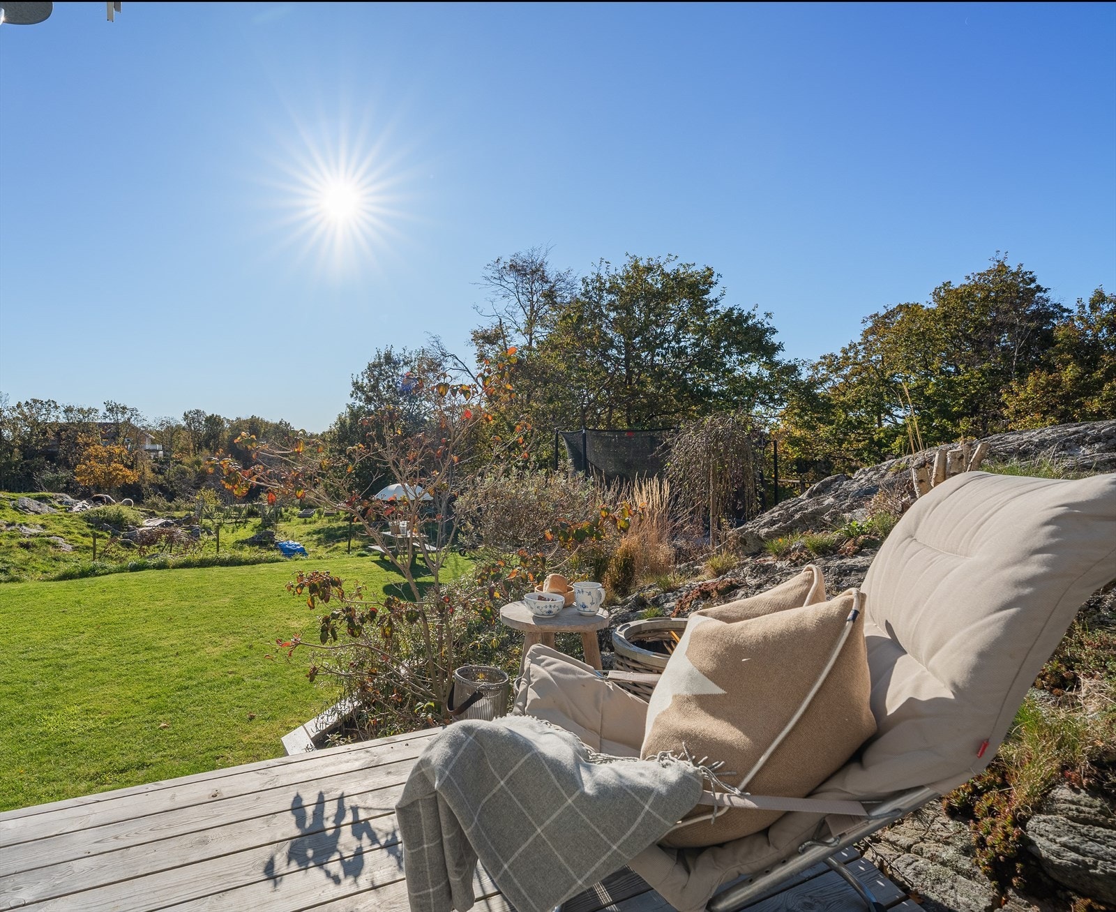 Langs gavlsiden av boligen er det laget en terrasse som strekker seg til inngangspartiet og som følger fjellet. Her er det blitt plass til en sittegruppe. Det er lagt varmt og kaldt vann i utekran som du finner på begge sider av boligen. Galleribilde
