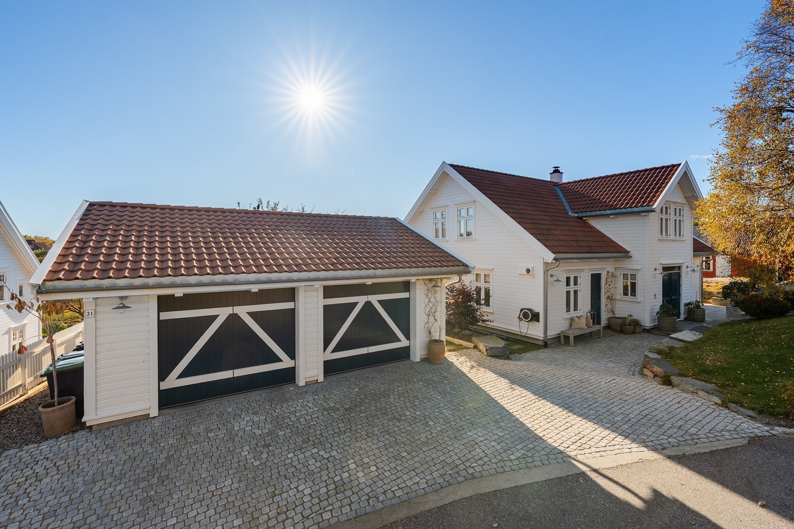 Innkjørselen er opparbeidet med brostein, og natursteinsmurer. Den doble garasjen har støpt dekke, automatiske portåpnere, el-bil lader og gode oppbevaringsmuligheter i kjøkkeninnredning. Galleribilde